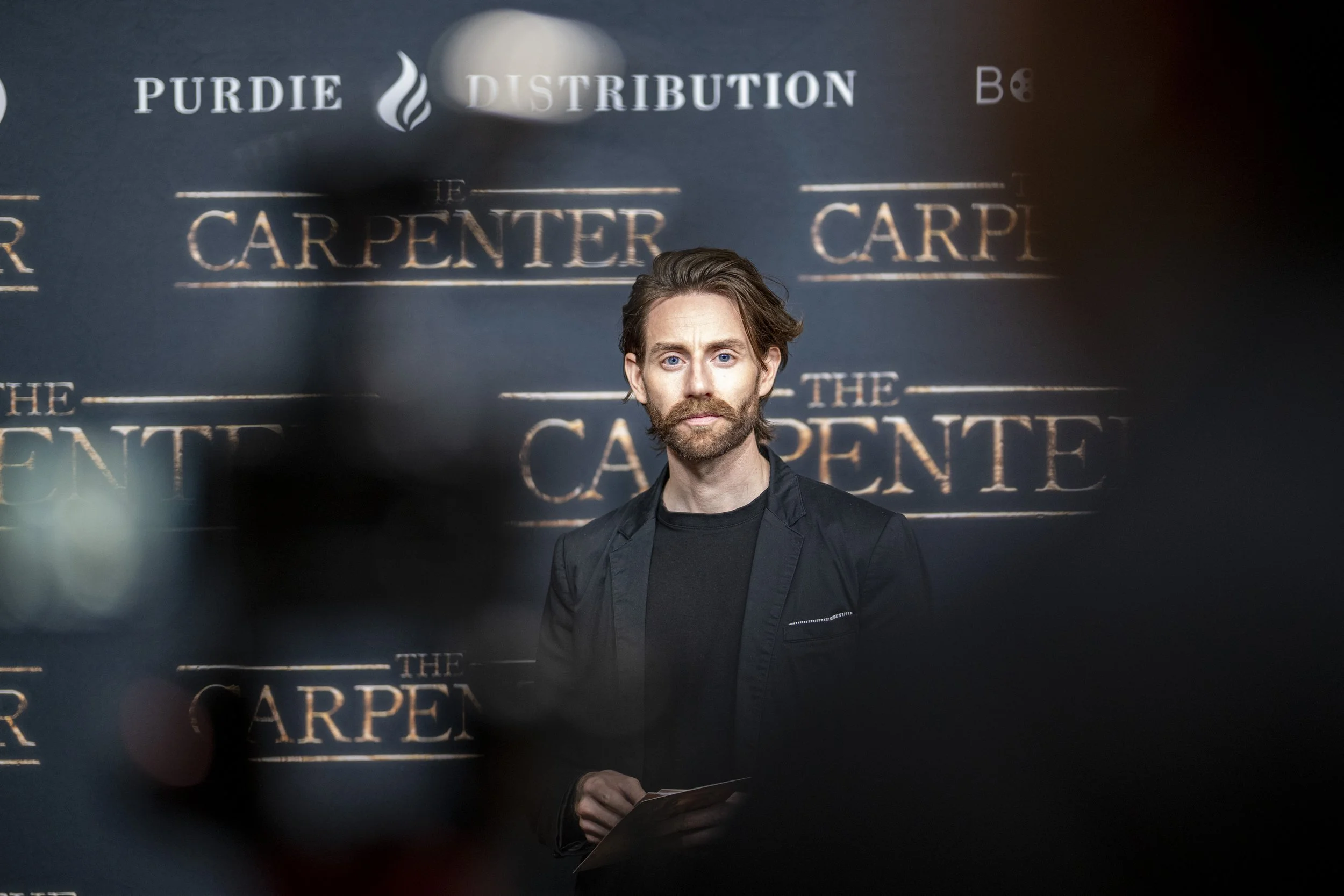 Man in black suit at 'The Carpenter' event