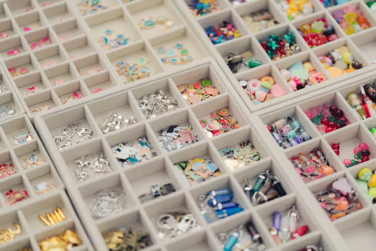organized storage container with multiple compartments filled with colorful nail art decorations and tiny accessories.