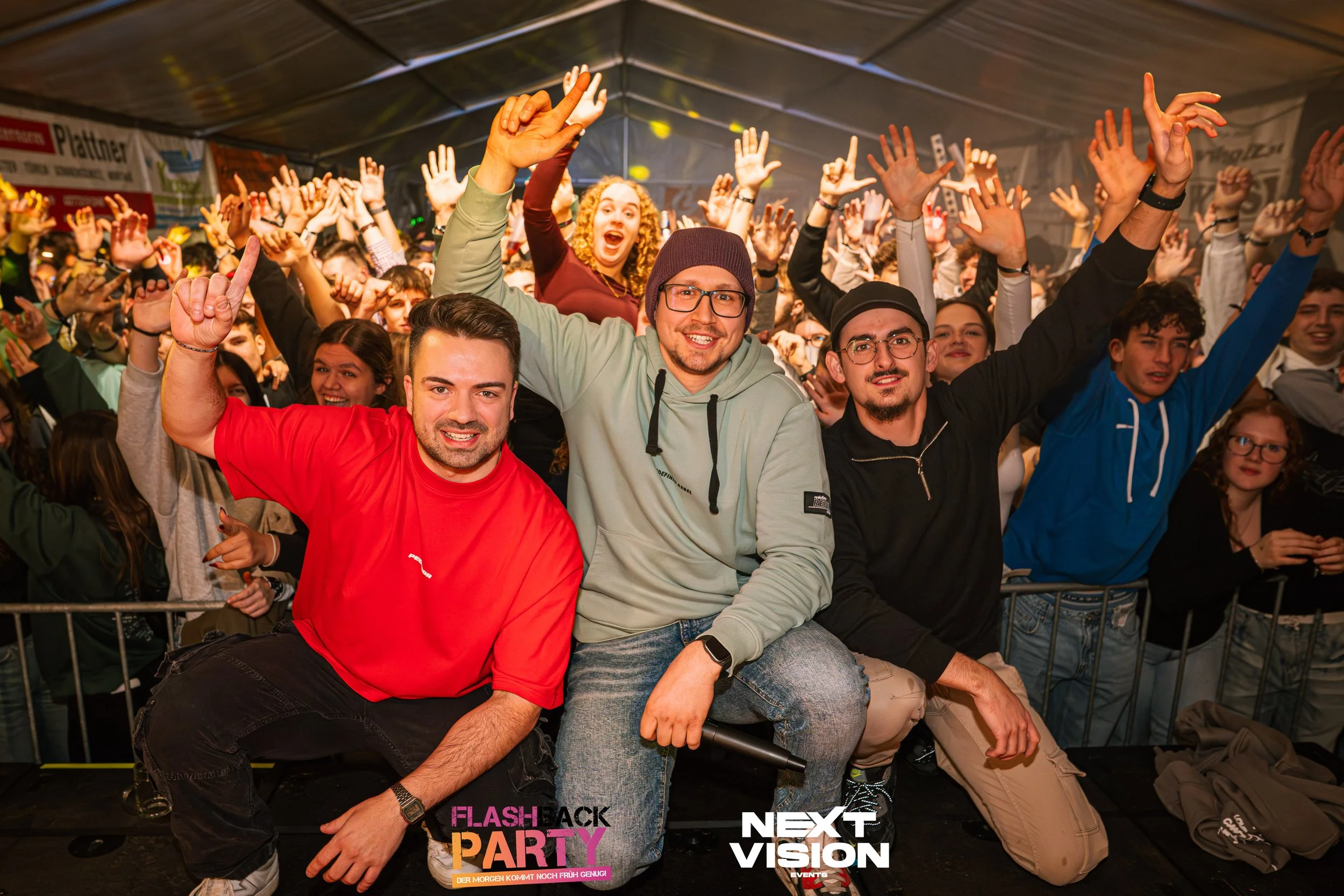 Menschen bei einer Partynacht im Zelt, vor einer Menschenmenge, die tanzt und jubelt, mit Logos 'FLASH BACK PARTY' und 'NEXT VISION' im Vordergrund.