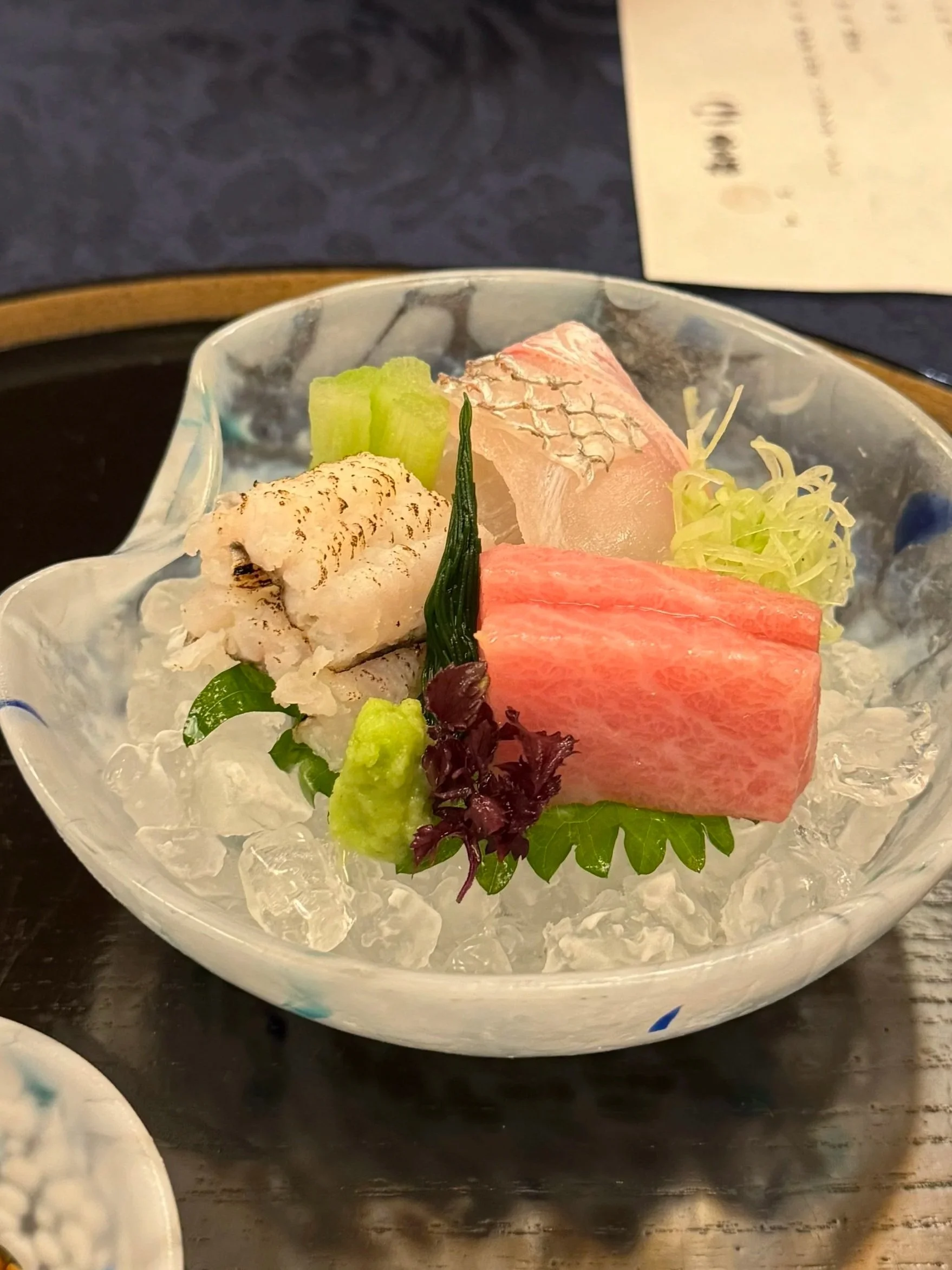 In kaiseki dining, vessels become storytellers – embodying the seasons, the maker’s hand, and the quiet dialogue between nature and the act of eating. Read about how food wares and materiality perform an ode for late summer in Uosaburo's August menu.