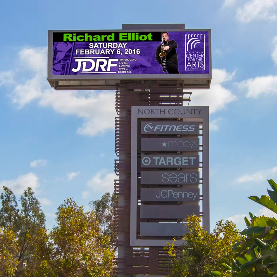 Billboard above a shopping center sign, featuring an event for Richard Elliot , supporting JDRF. 
