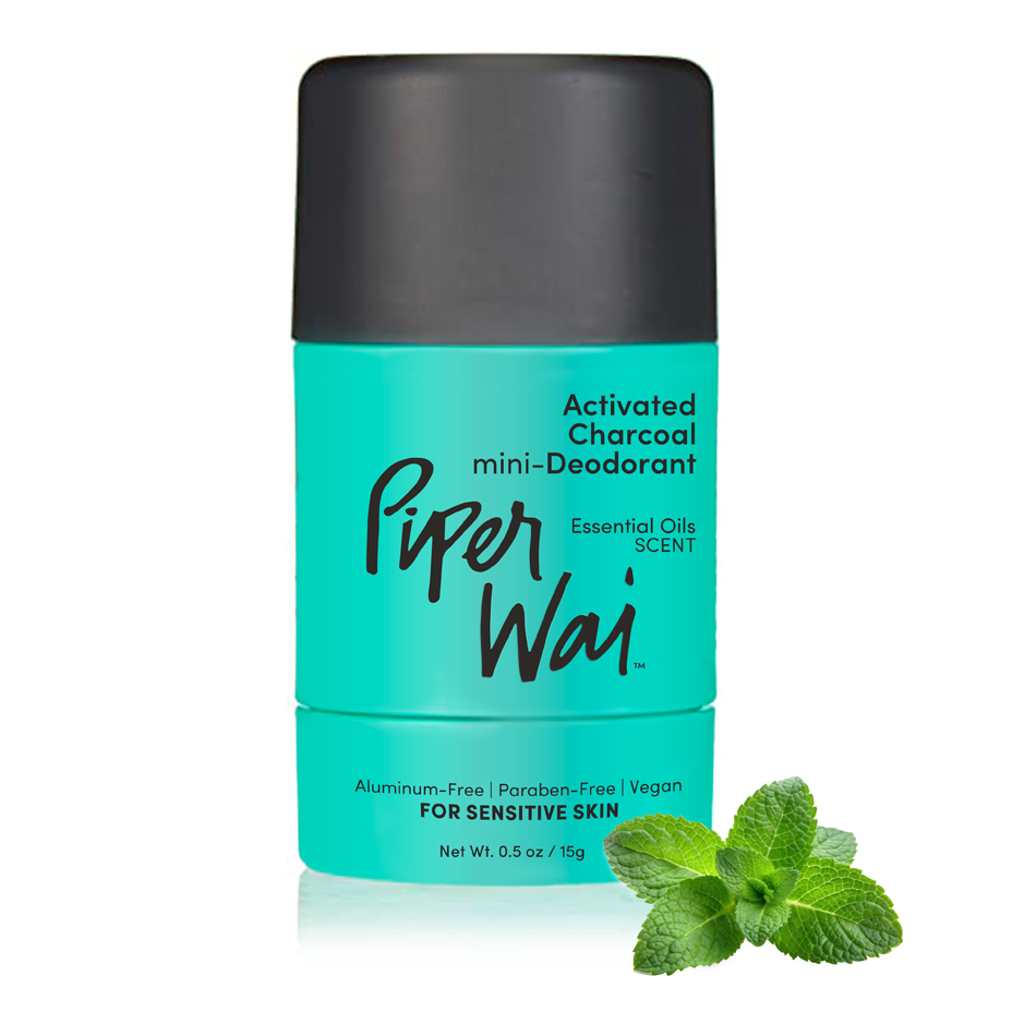 Piper Wai activated charcoal mini-deodorant with essential oils, in a turquoise container, next to a mint sprig.