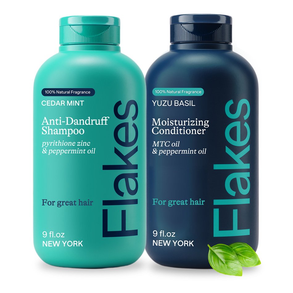Two bottles of hair care products: one teal bottle of Flakes Anti-Dandruff Shampoo with cedar mint fragrance, pyrithione zinc, and peppermint oil; one dark blue bottle of Flakes Moisturizing Conditioner with yuzu basil fragrance, MTC oil, and peppermint oil. Each bottle is labeled "For great hair" and contains 9 fl. oz.
