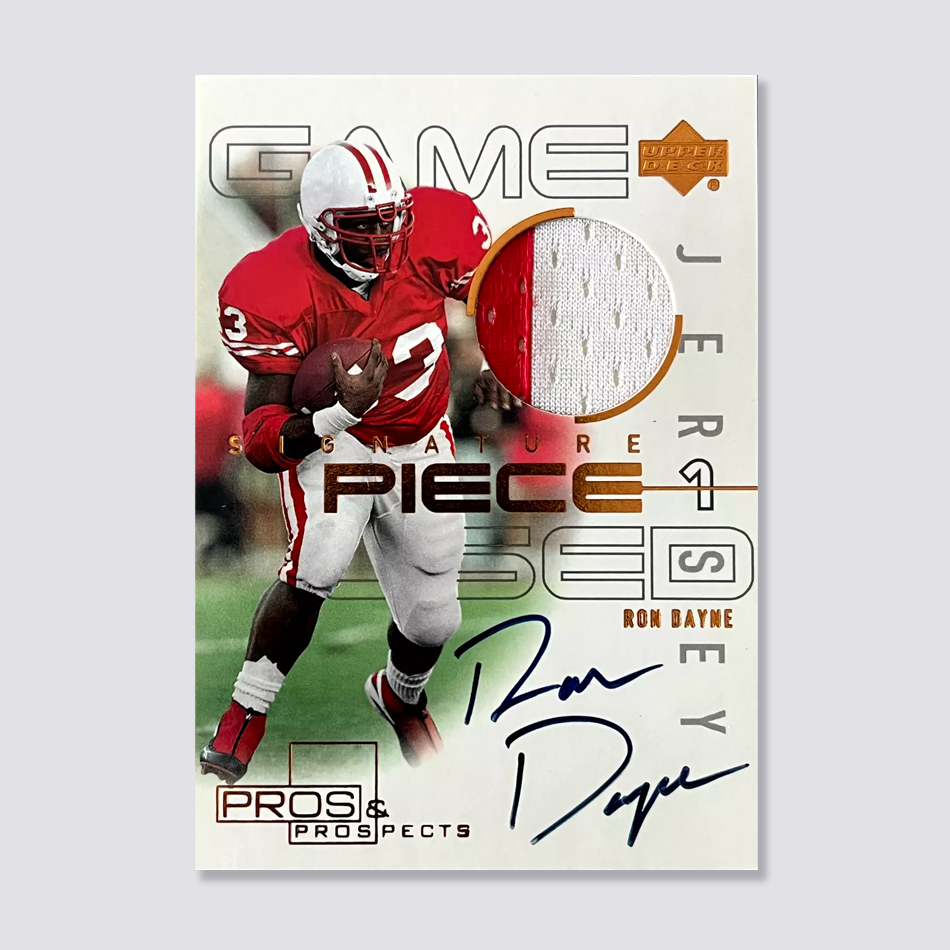 A sports trading card featuring a football player holding a ball, wearing a red jersey with the number 33. The card includes a piece of white fabric labeled 'Game Jersey.' The player's signature is in blue ink. The card is branded with 'Upper Deck' and 'Pros & Prospects.'