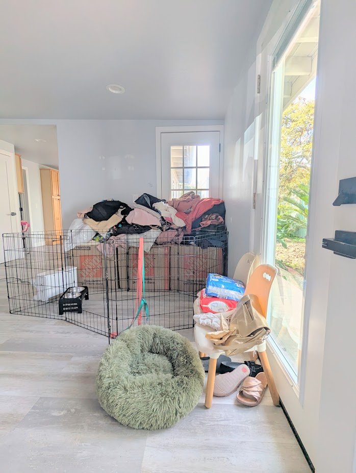 Encinitas California Moving Packing Unpacking Before After showcasing chaotic messy cluttered living room family room new house moving boxes piles of clothes unusable space lacking function lacking flow functional space