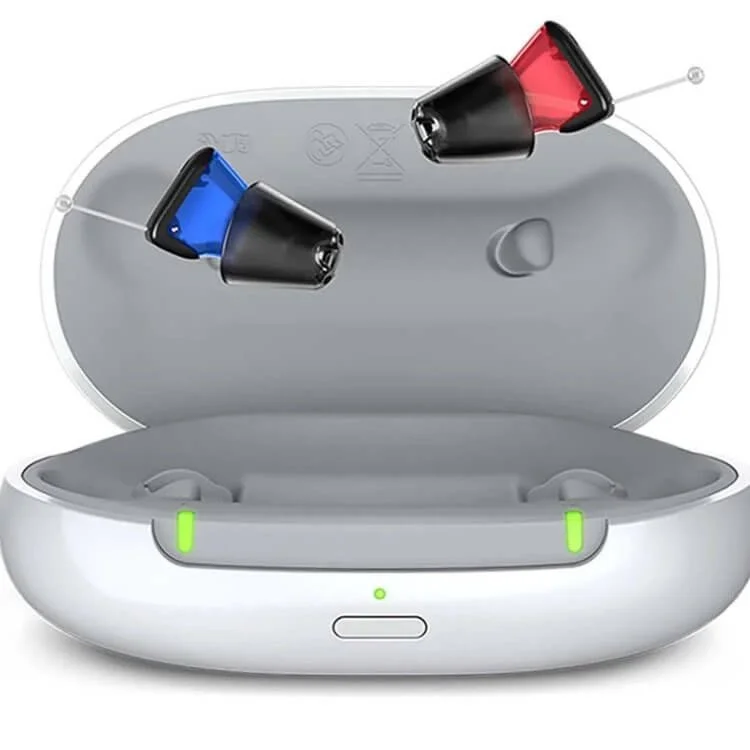 Rechargeable hearing aid set with red and blue in-ear pieces and open charging case on white background.