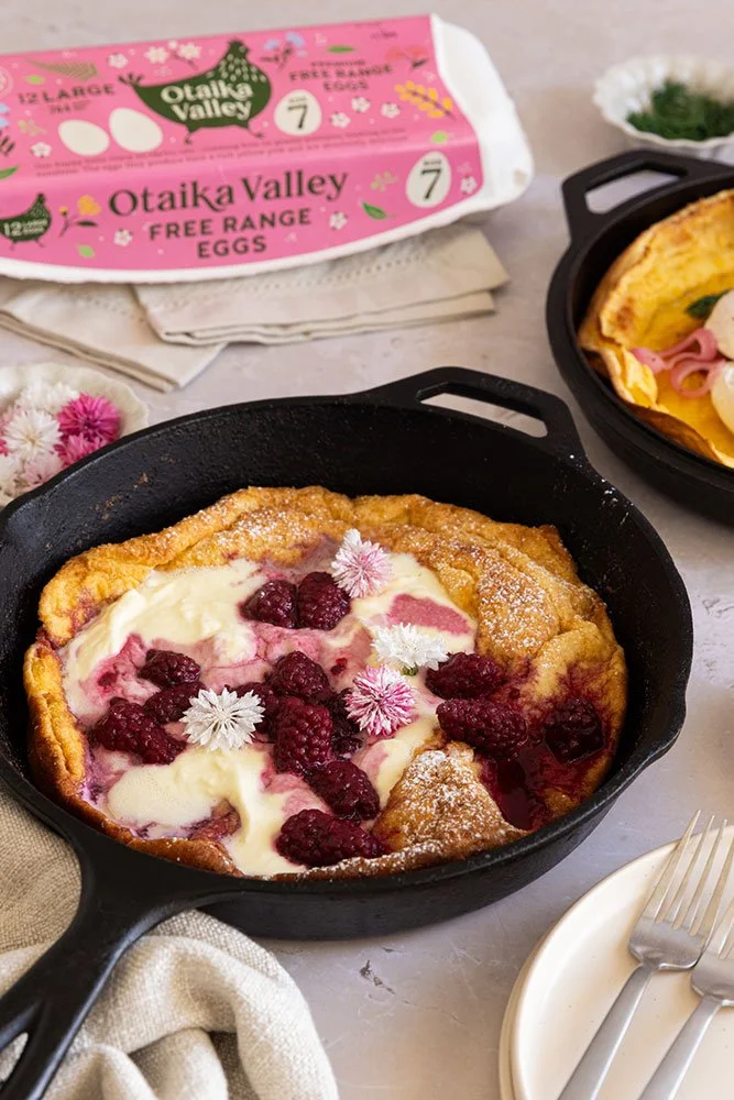 Baby Dutch pancakes topped with boysenberries and cream