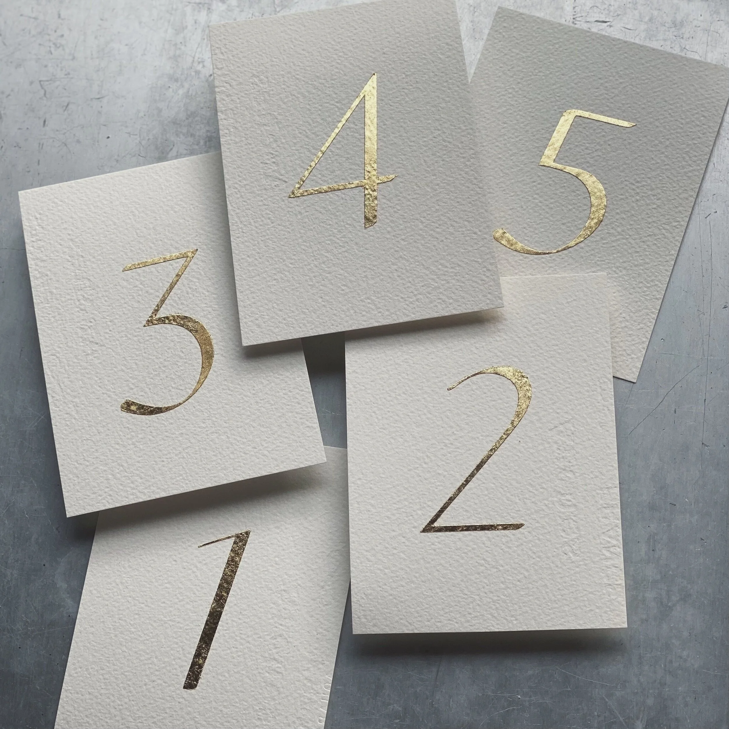 白いカードに金色の数字が書かれている。数字は1から5まで。