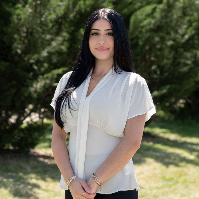 Smiling woman with dark hair and white shirt