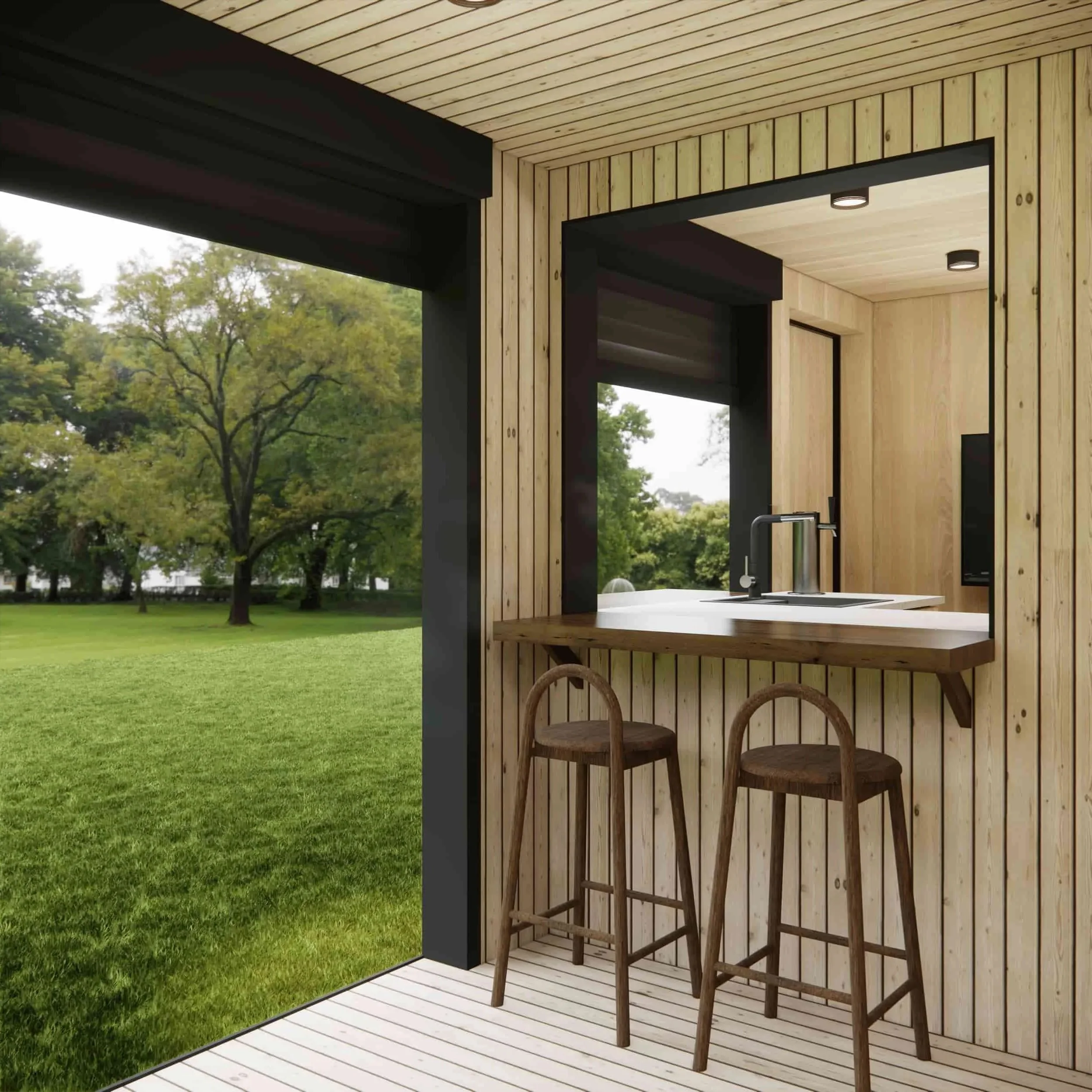 Interior view of a modern outdoor kitchen with wooden walls and ceiling, bar stools, and a view of green trees outside.