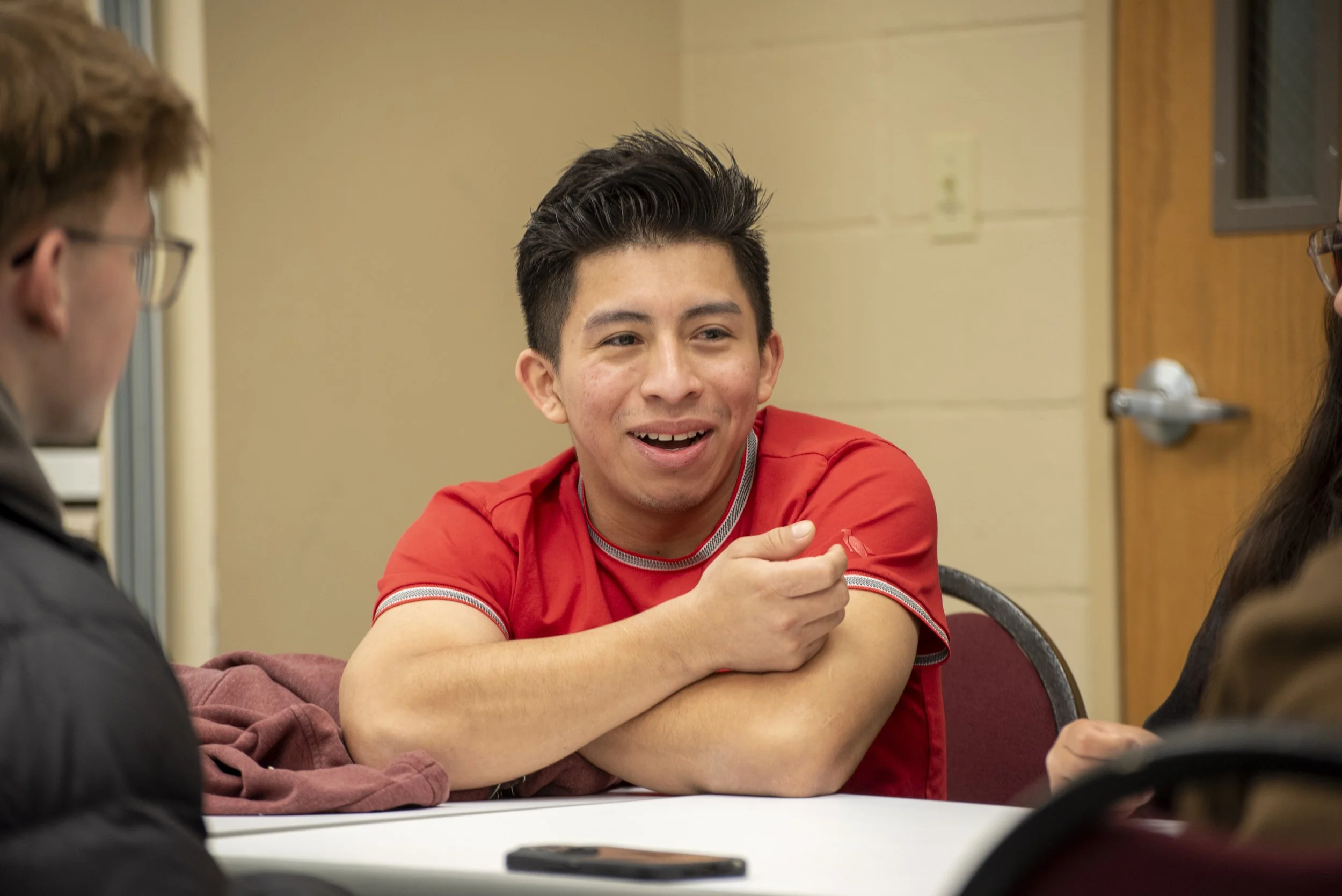 Dany Cruz, a community member, talks with GC students during an adult English language learners class.