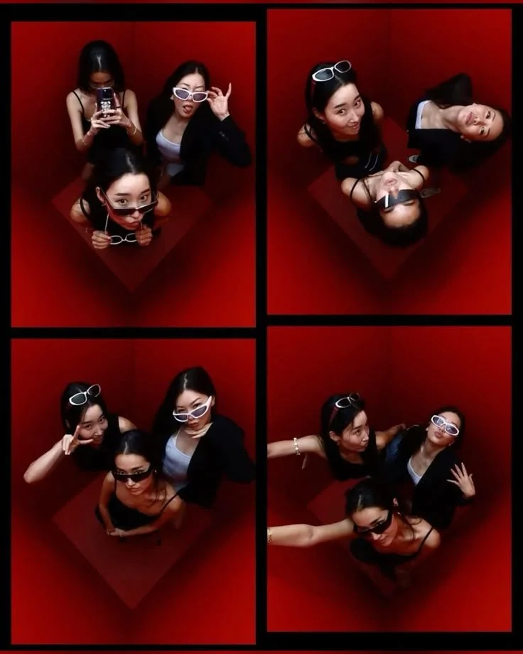 Four-panel photo collage of three women posing inside a small red square photo booth, wearing sunglasses and making playful gestures.