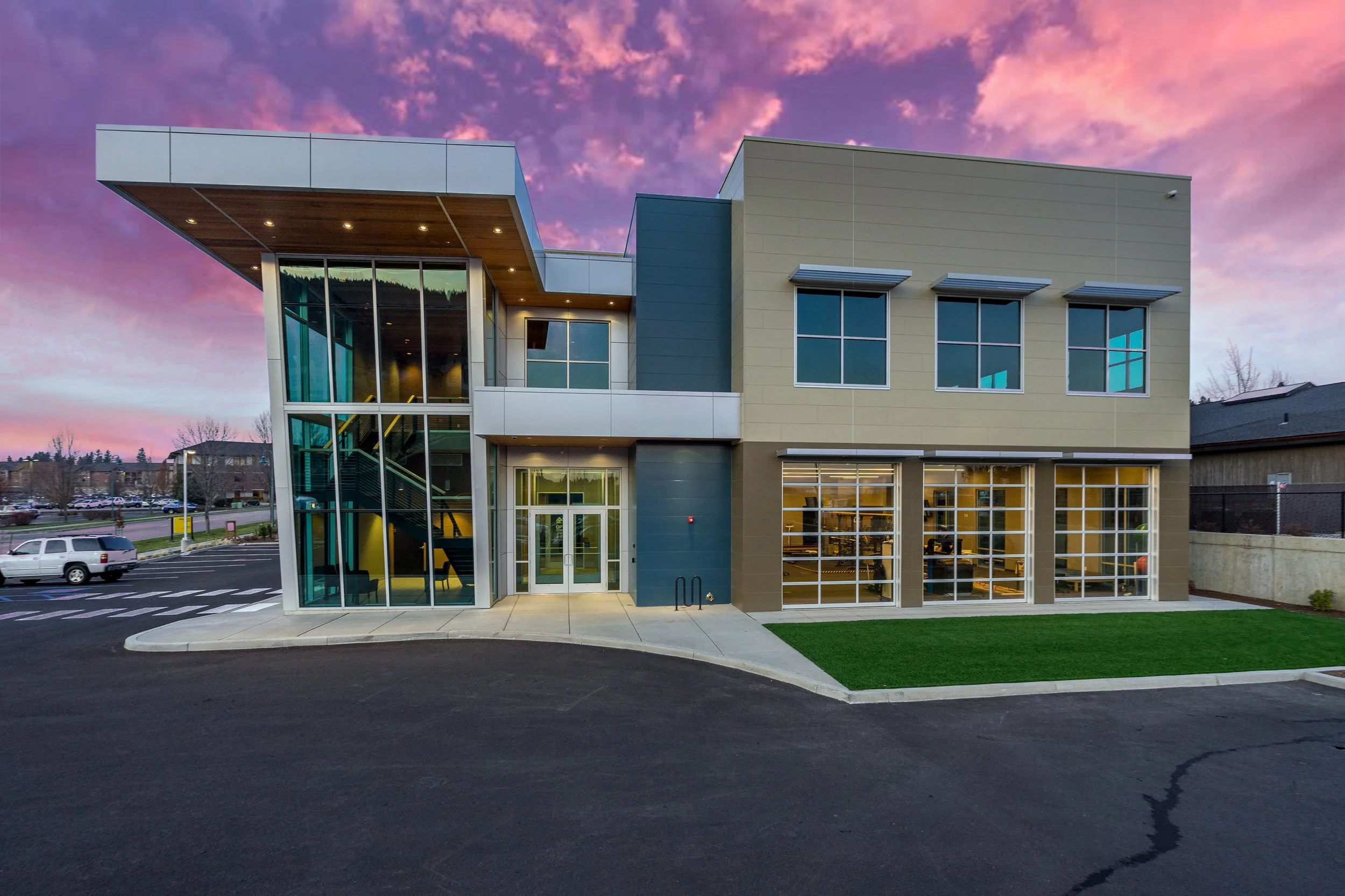 A commercial building with large glass windows and 3 glass garage doors