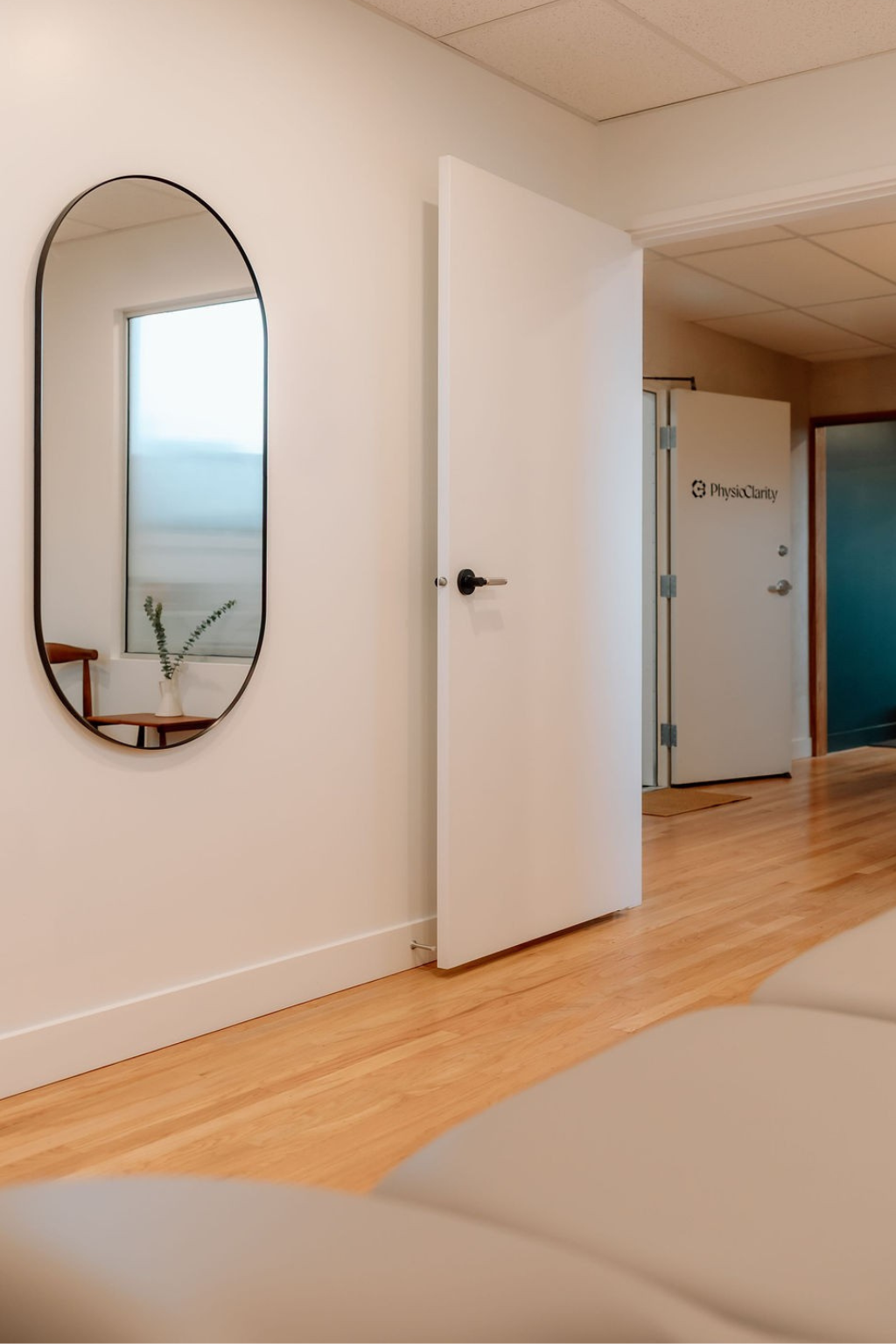 Woman practicing seated forward bend yoga stretch on a black yoga mat in a living room