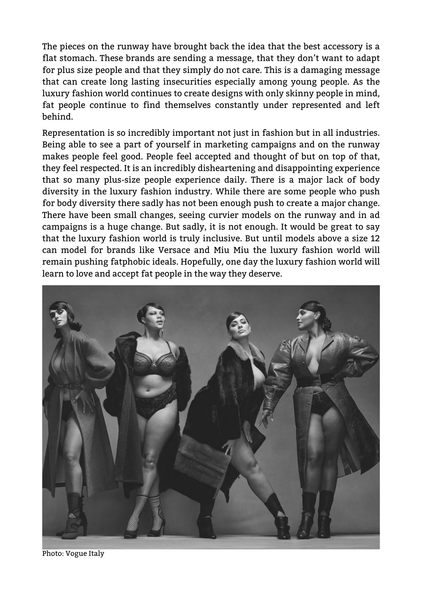 Black and white photo of five women in fashionable outfits, posing confidently on a studio floor, with a plain background.