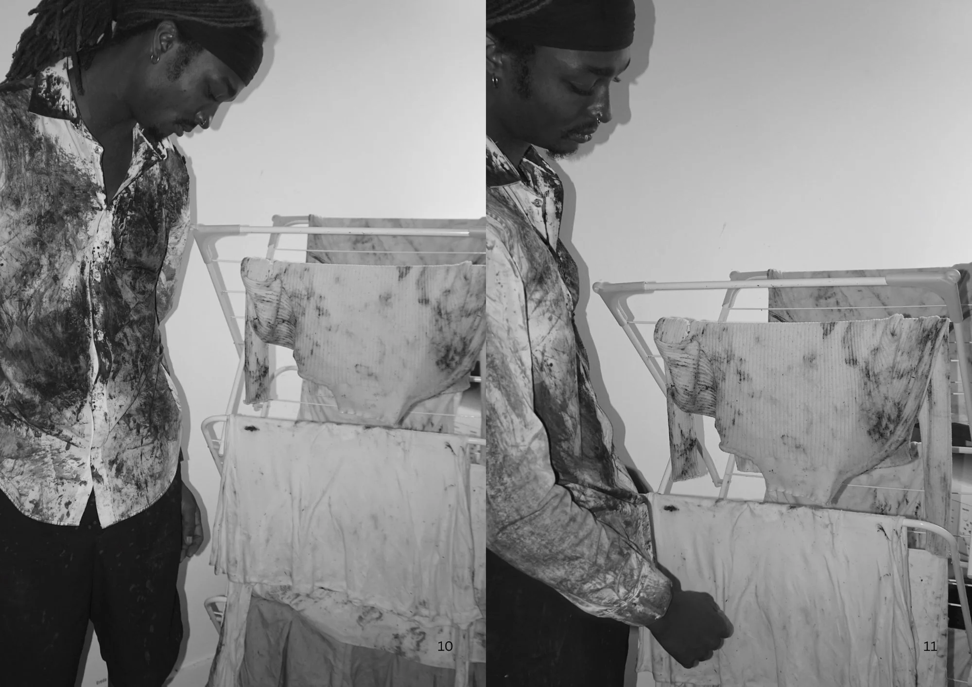 A black and white photo of a person with long dreadlocks wearing a patterned shirt, looking down at laundry hanging on a drying rack.