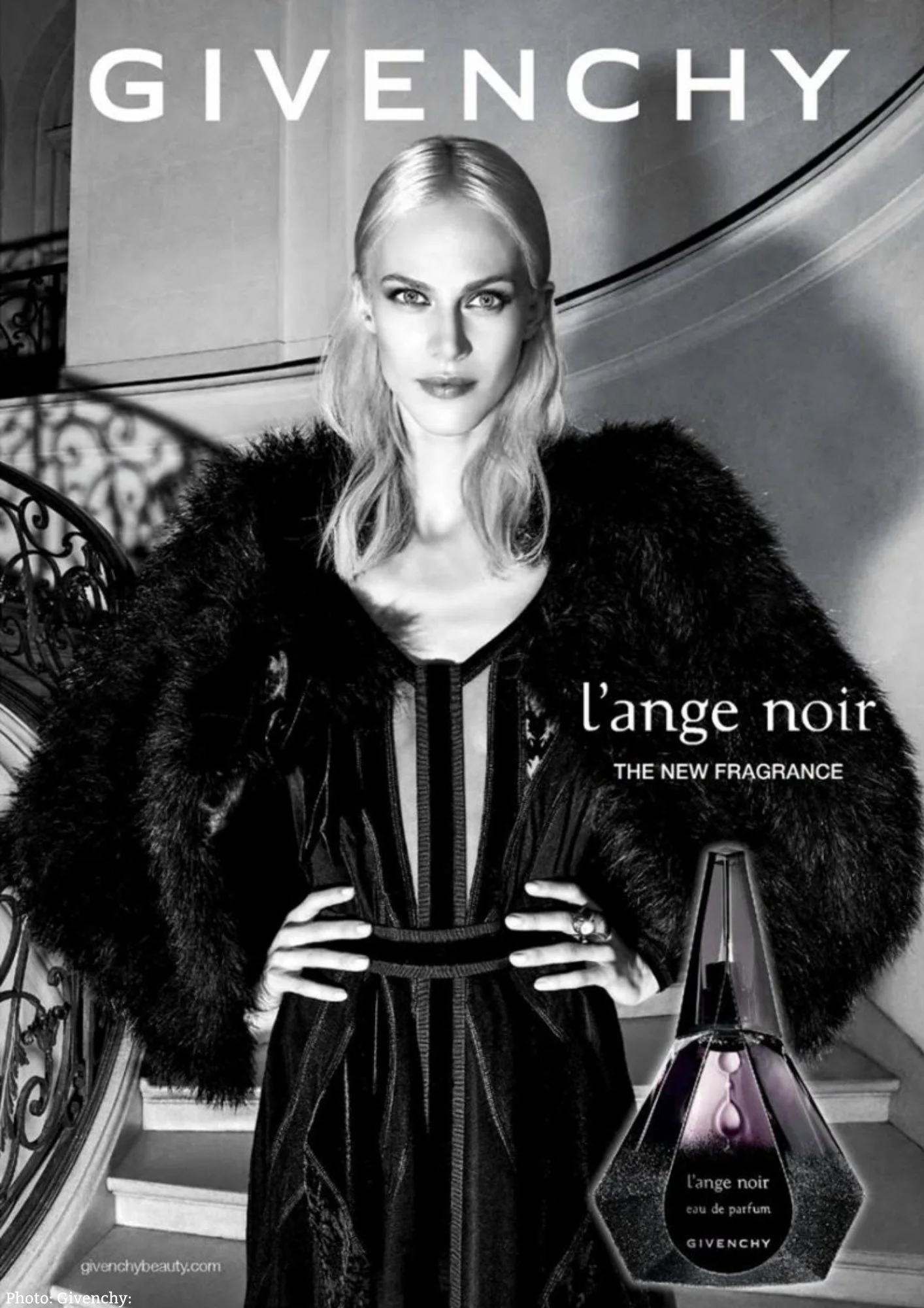A woman with blonde hair and piercing eyes posing on a staircase, advertising Givenchy's fragrance 'L'ange Noir' in black and white.