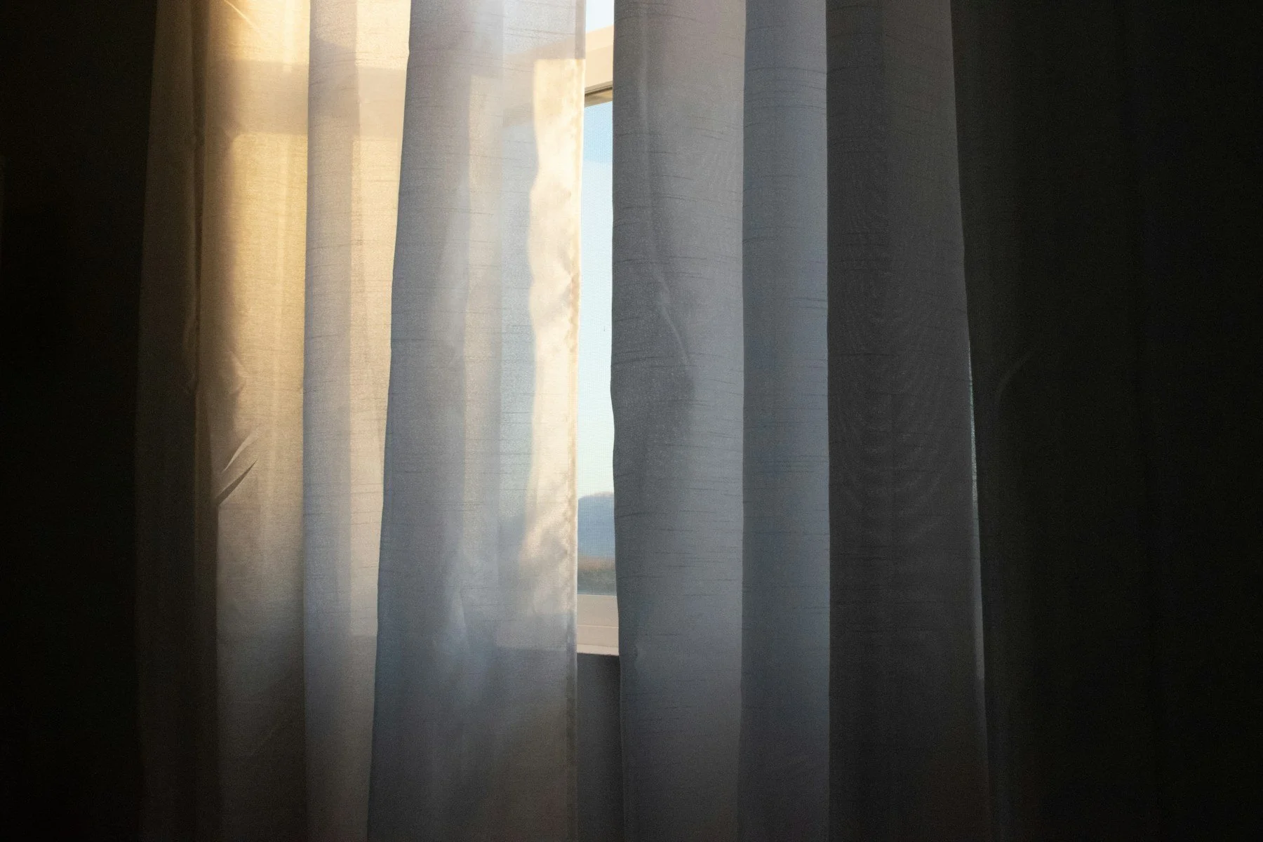 Soft sunlight through pale curtains, a calm moment for when deep breathing makes anxiety worse