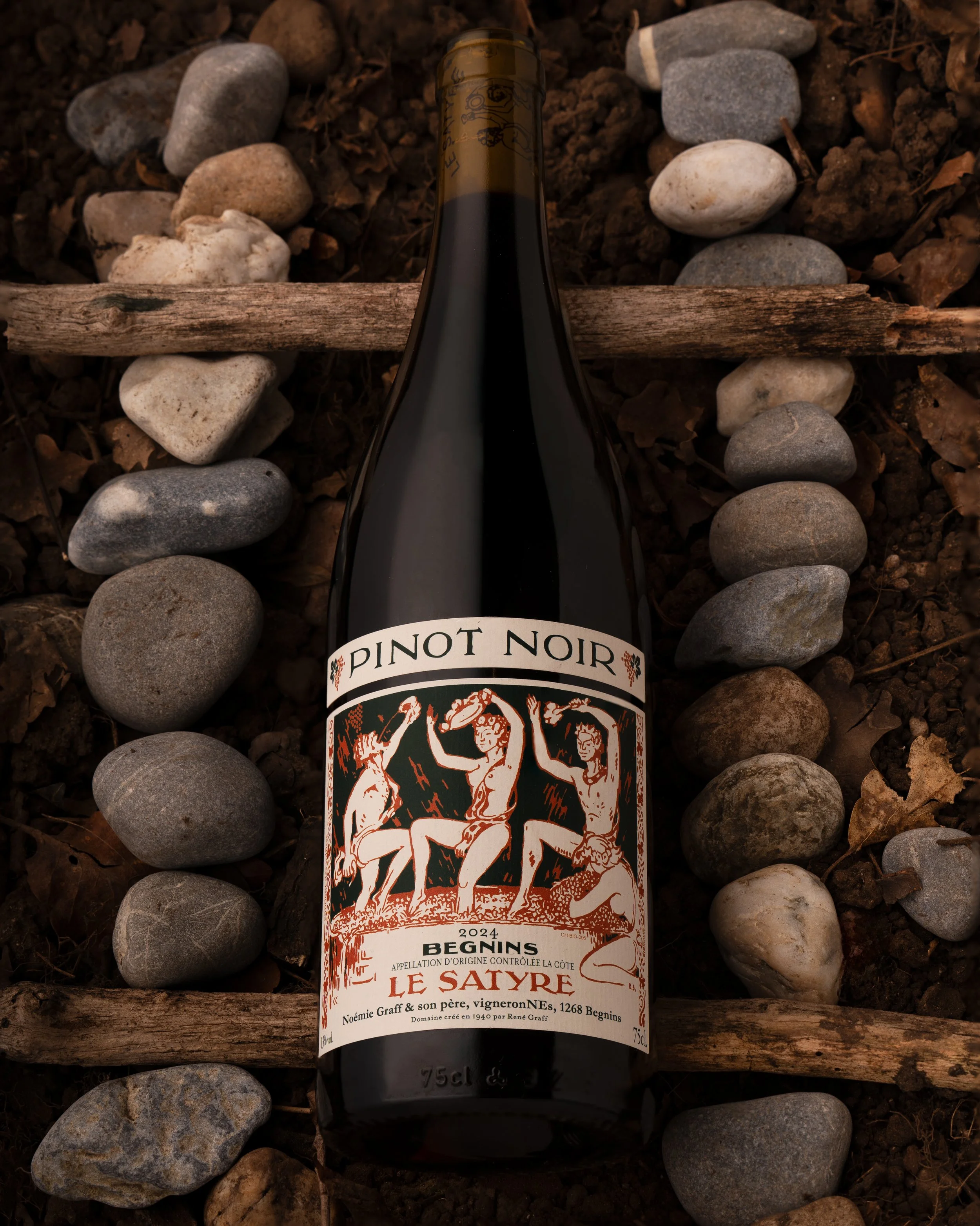 Pinot Noir Le Satyre du Domaine Le Satyre, à Begnins, posé entre des galets et des lattes de bois