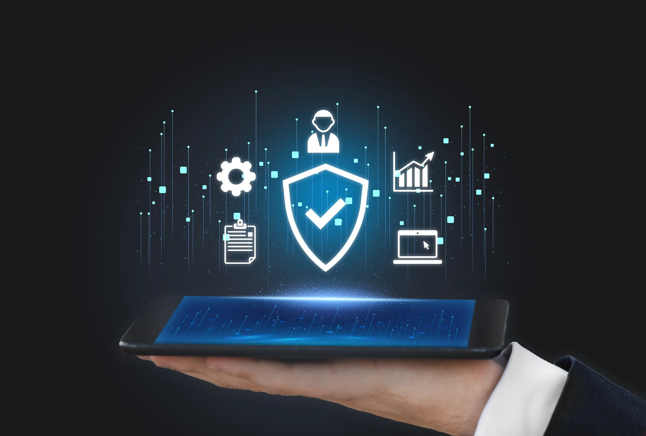 A hand holds a smartphone with digital icons and graphics floating above it, including a shield with a checkmark, gear, document, person, chart, and laptop, representing cybersecurity and data protection.