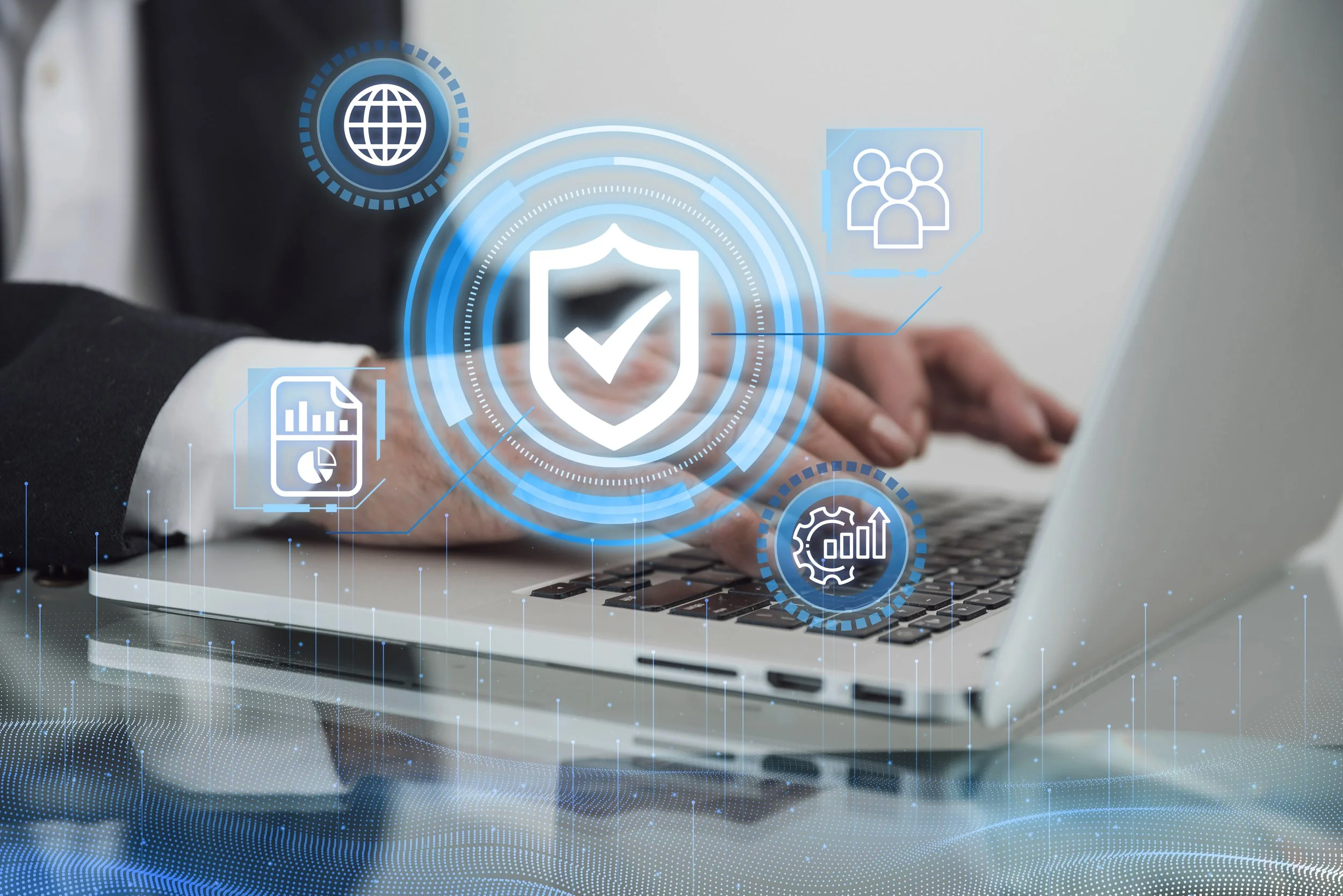 Person in a suit typing on a laptop with digital security icons and graphics, including a shield with a checkmark, globe, pie chart, group of people, and gears surrounding the laptop.