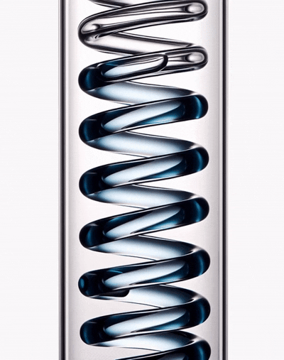 Close-up of a metallic coil spring inside a transparent glass container.