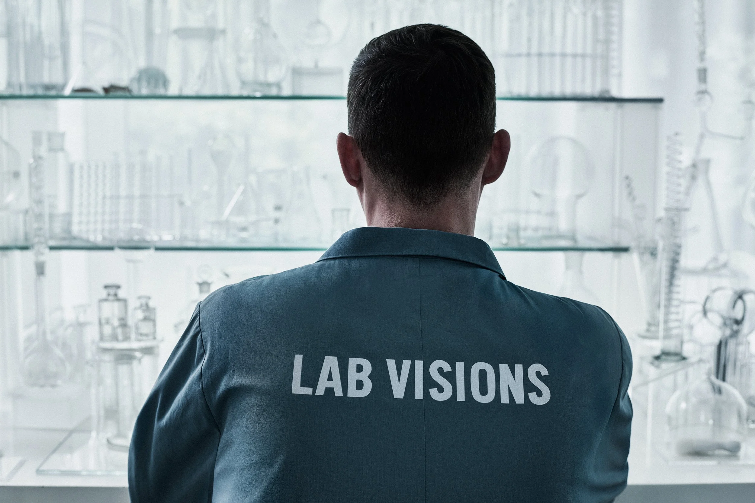 Person with dark hair wearing a lab coat with