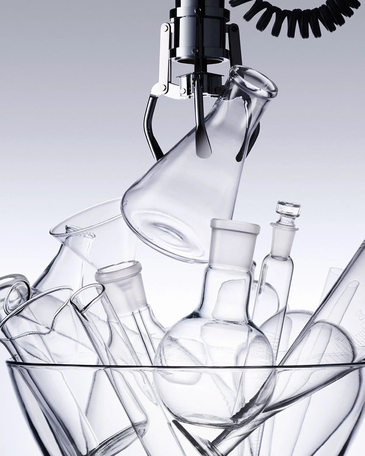 Laboratory glassware, including beakers, flasks, and test tubes, with a robotic arm holding a glass flask.