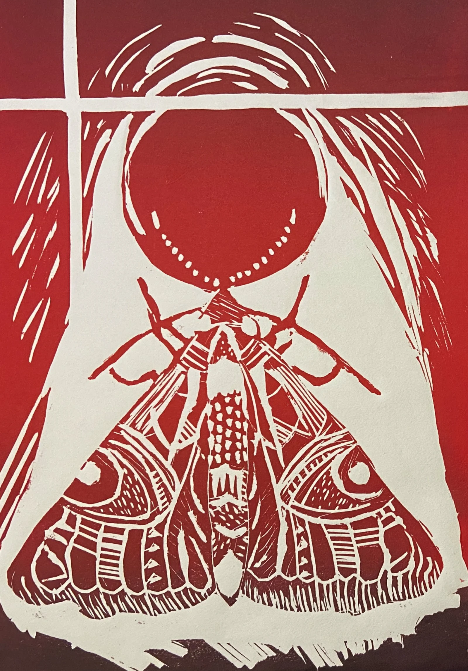 Shades of a red linocut of a mother with the red circle on top