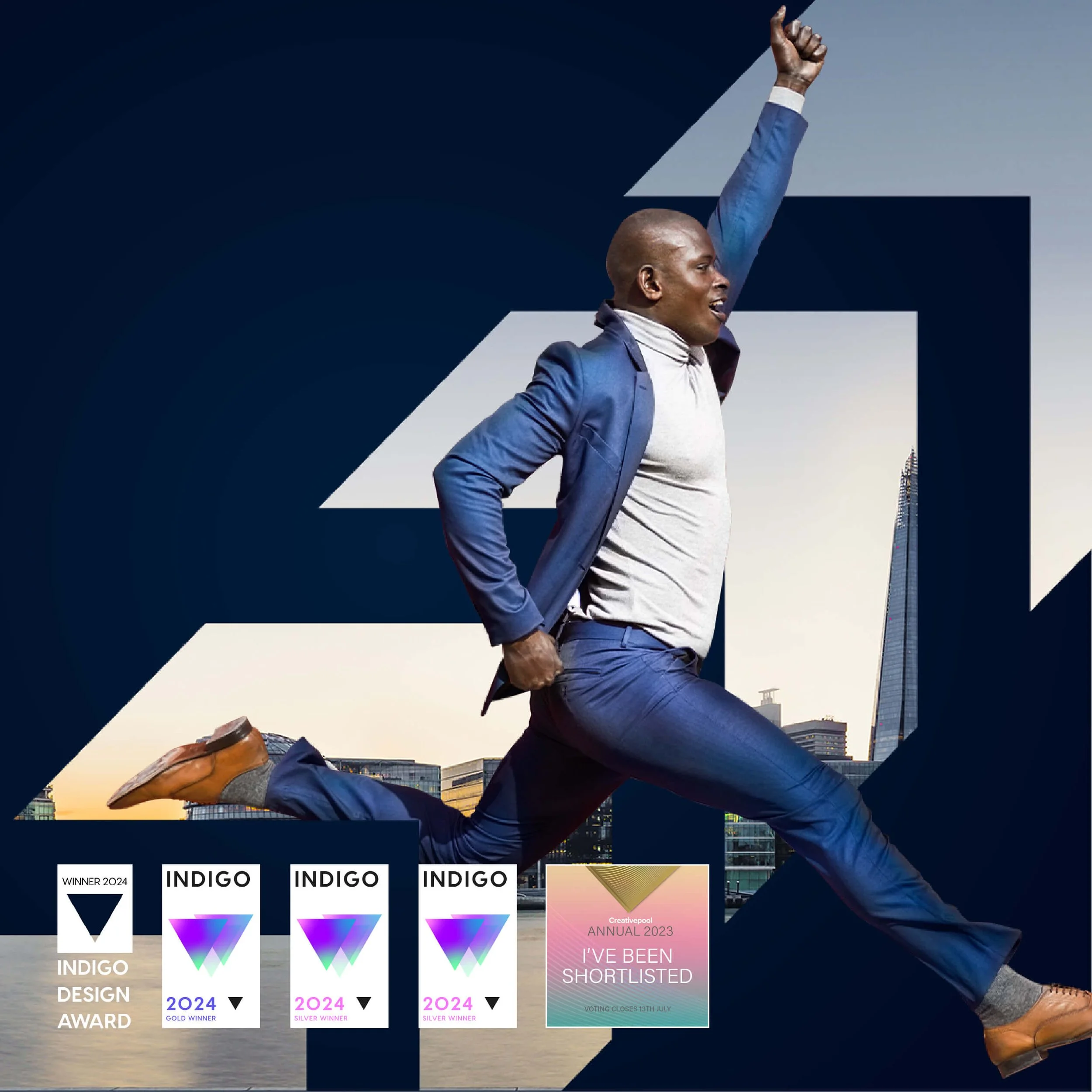 A man in a blue suit and gray shirt is jumping in front of a cityscape with tall buildings, with his right arm raised in a victorious gesture.