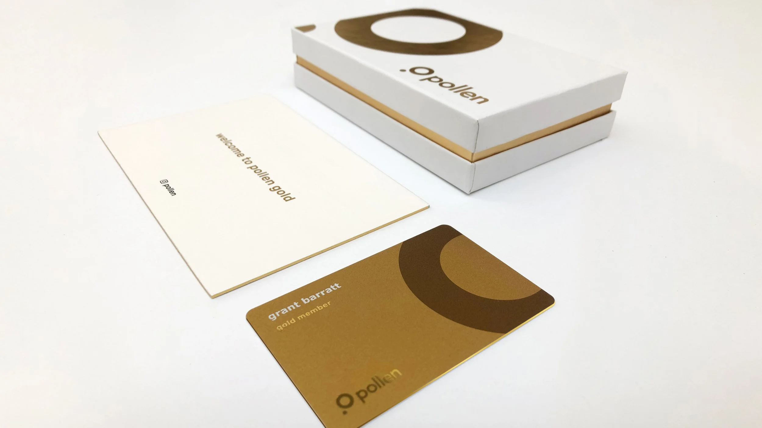 Gold membership card, greeting card, and a box from pollen, displayed on a white surface.