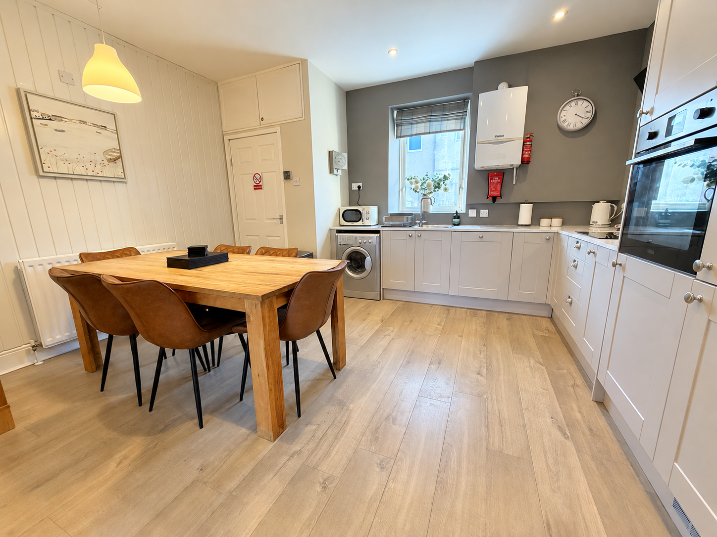 Spacious kitchen and dining area at The Sands Cottage in Seahouses, featuring a stylish Wren fitted kitchen, modern appliances and a dining table for six guests.