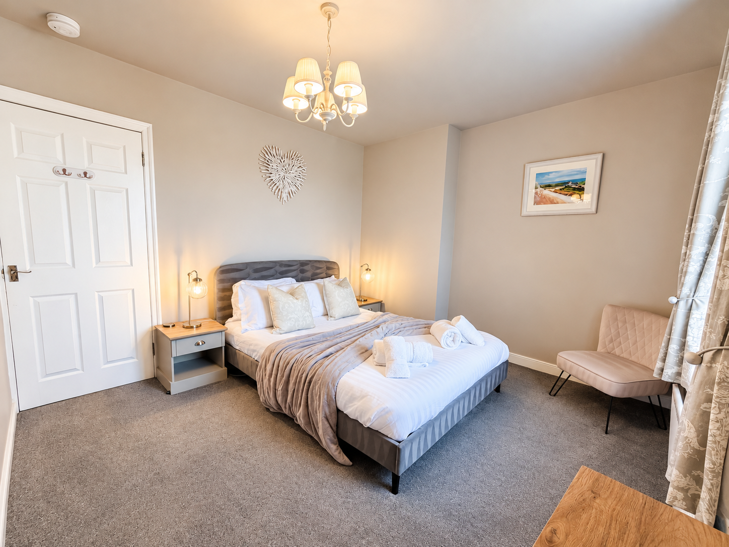 Beautifully presented king-size bedroom at The Sands Cottage in Seahouses, featuring a comfortable pocket-sprung mattress, bedside tables, soft lighting and elegant neutral furnishings.