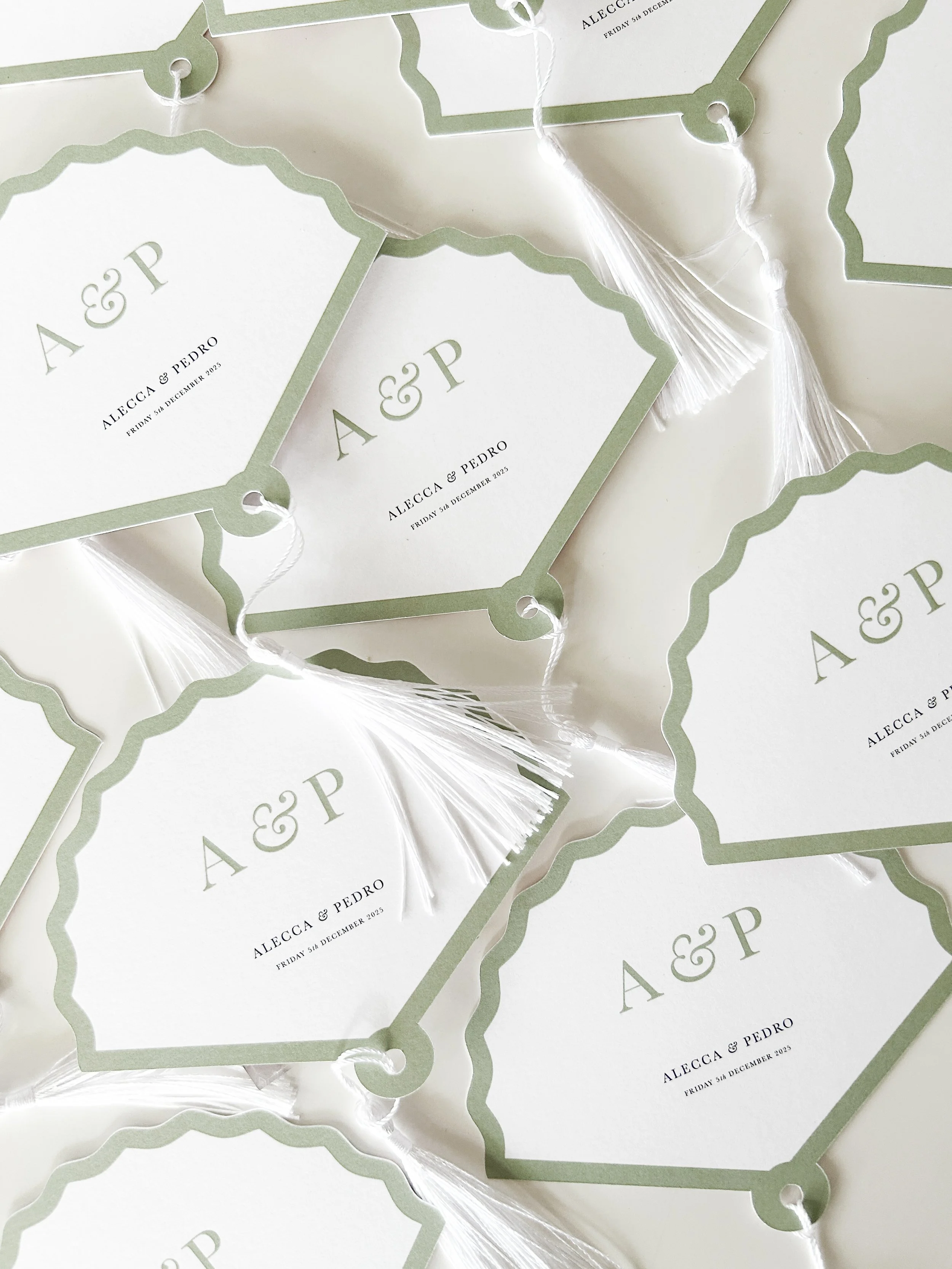 Wedding place cards with green border and white background, displaying names Alecca and Pedro, and wedding date, Friday 5th December 2025.