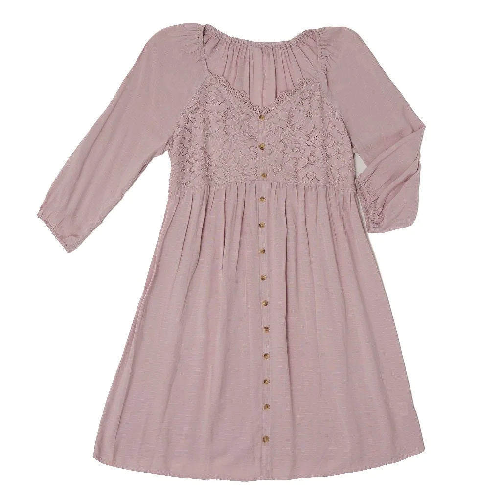 A light pink, long-sleeved dress with lace detailing on the bodice and small buttons down the front.