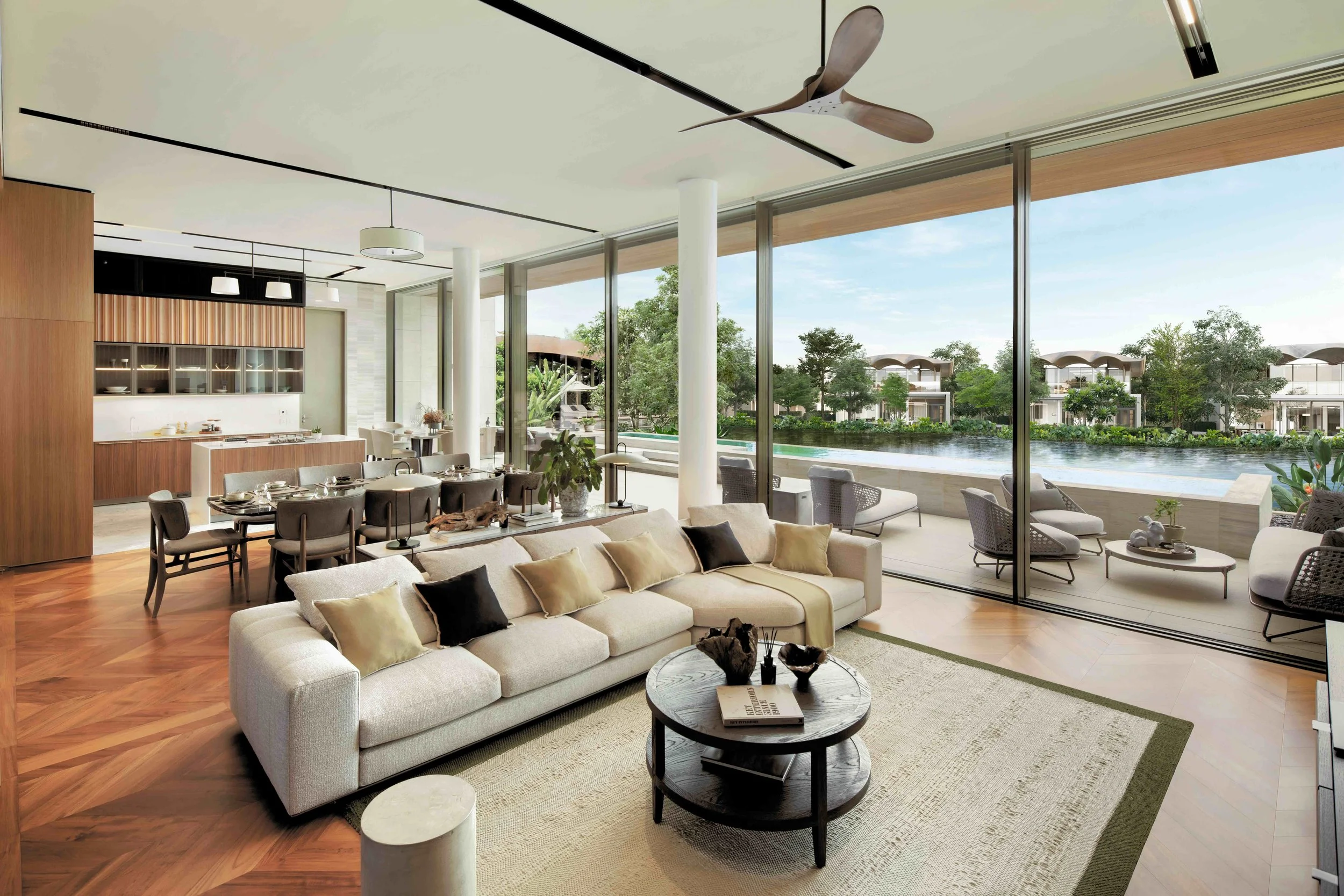 Open-plan living space at Six Senses Residences Bangkok, featuring natural stone and timber finishes, floor-to-ceiling glass, soft neutral interiors, and views across the lagoon and surrounding forest, designed to create a calm, wellness-led living