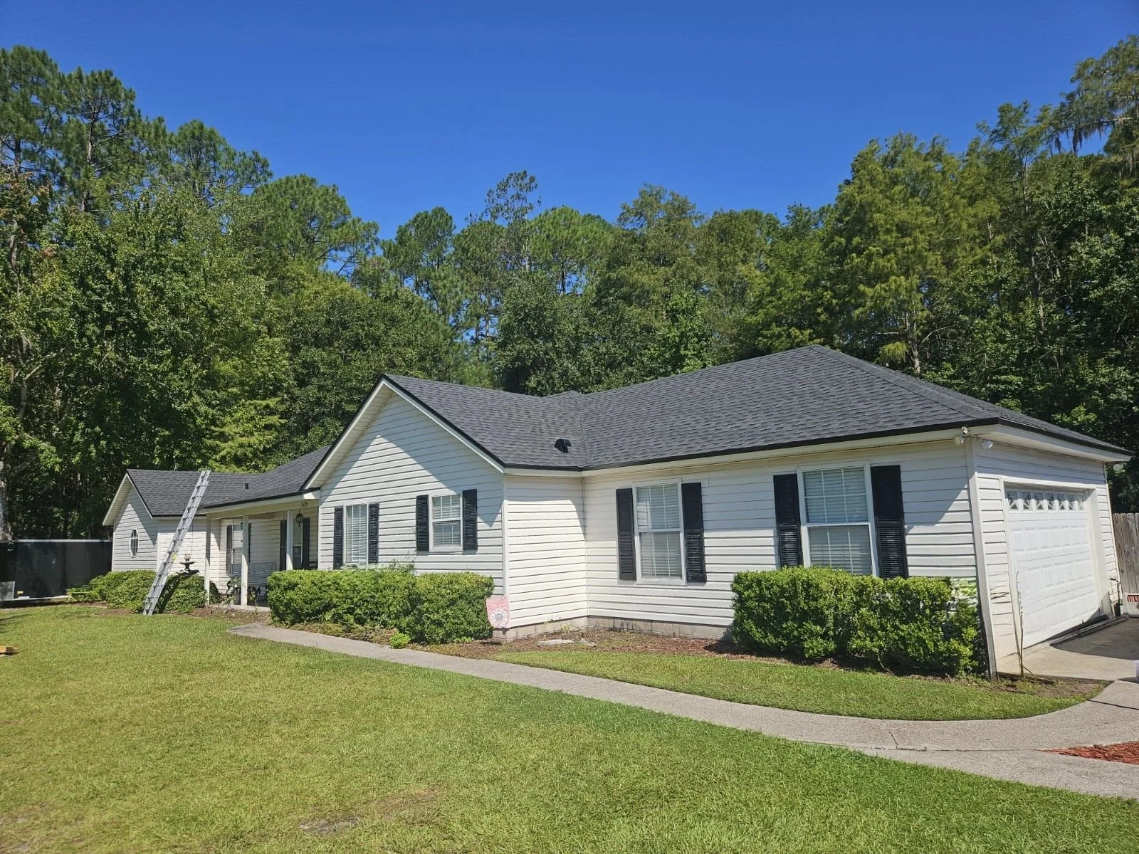 Storm damaged roof with new shingles installed by Shaka Roofing 
