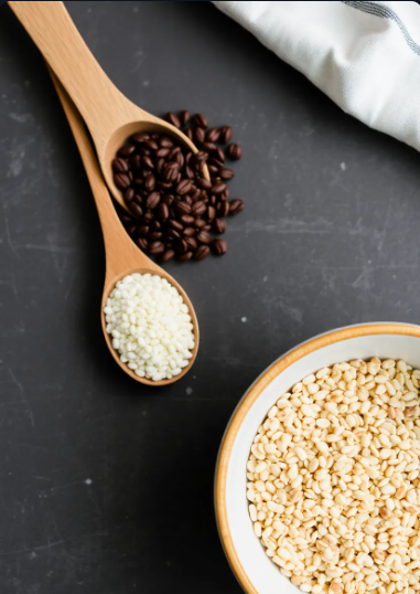 Black and white baking chips in a bowl and on spoons on a dark surface.