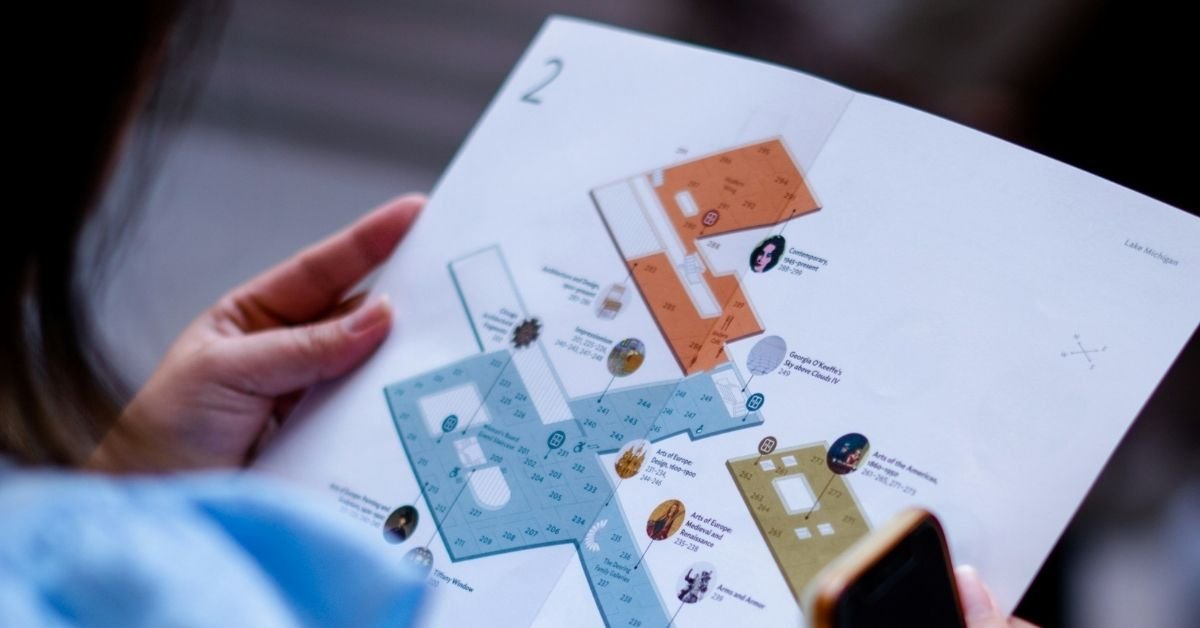 woman holding a museum map and a cell phone