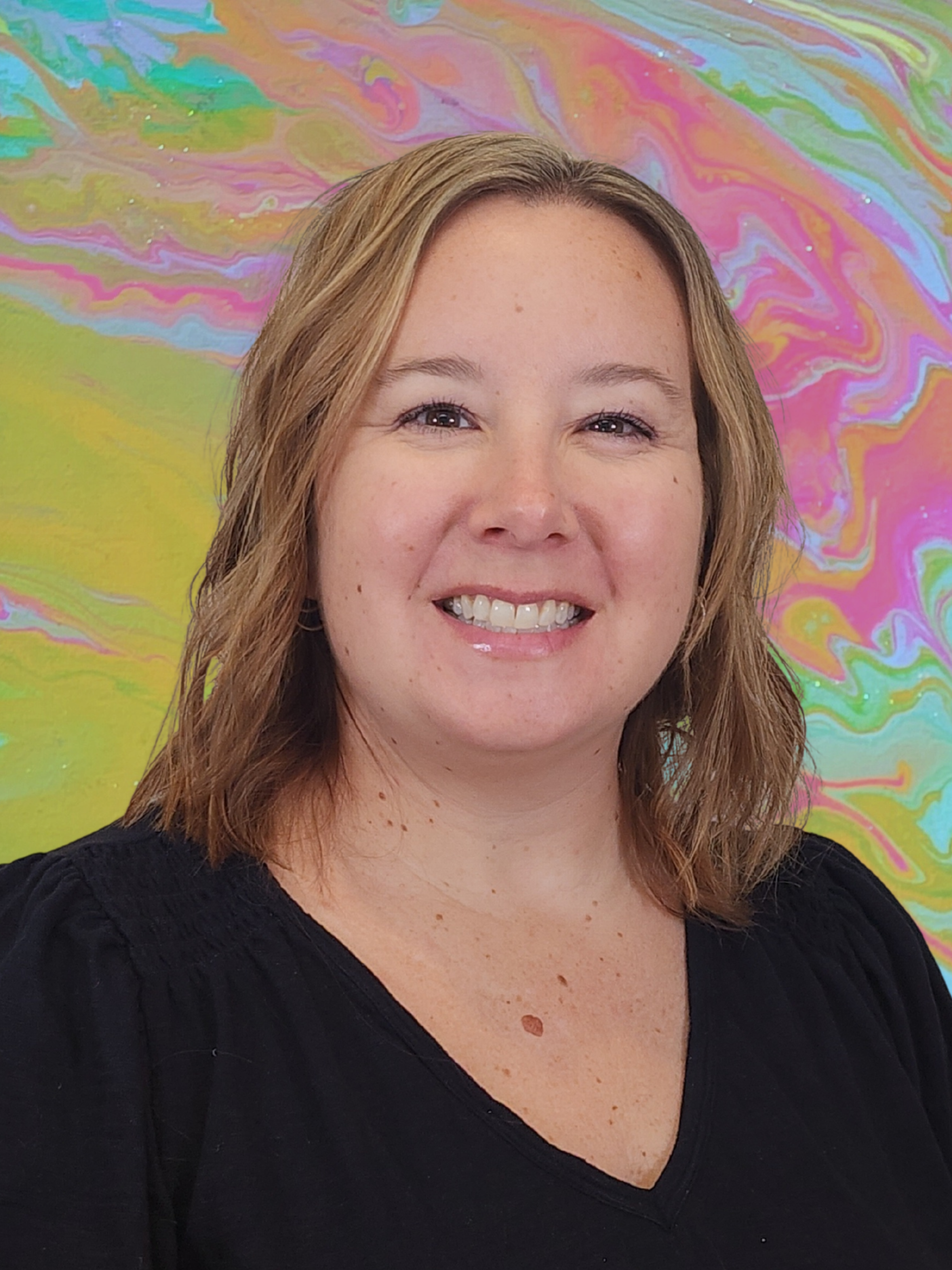 Headshot of artist and author Lindy Hedges with a bright colorful background.
