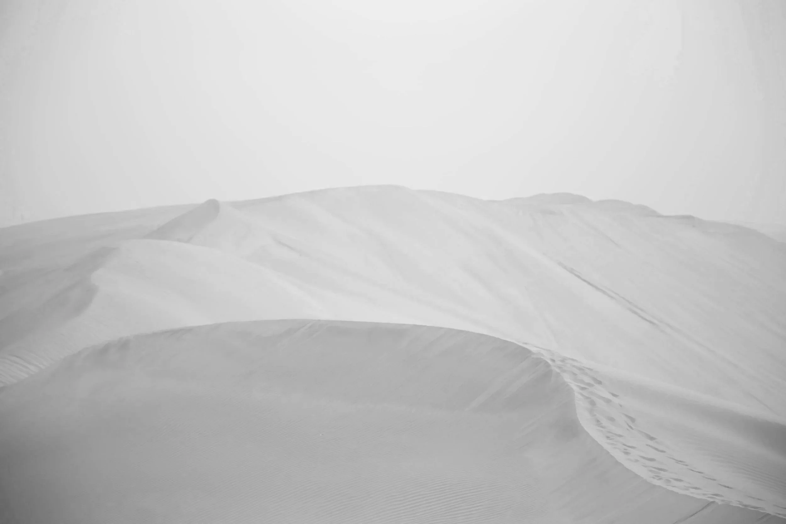 砂丘の風景、白と灰色のトーンで表現された砂の山々と砂の模様