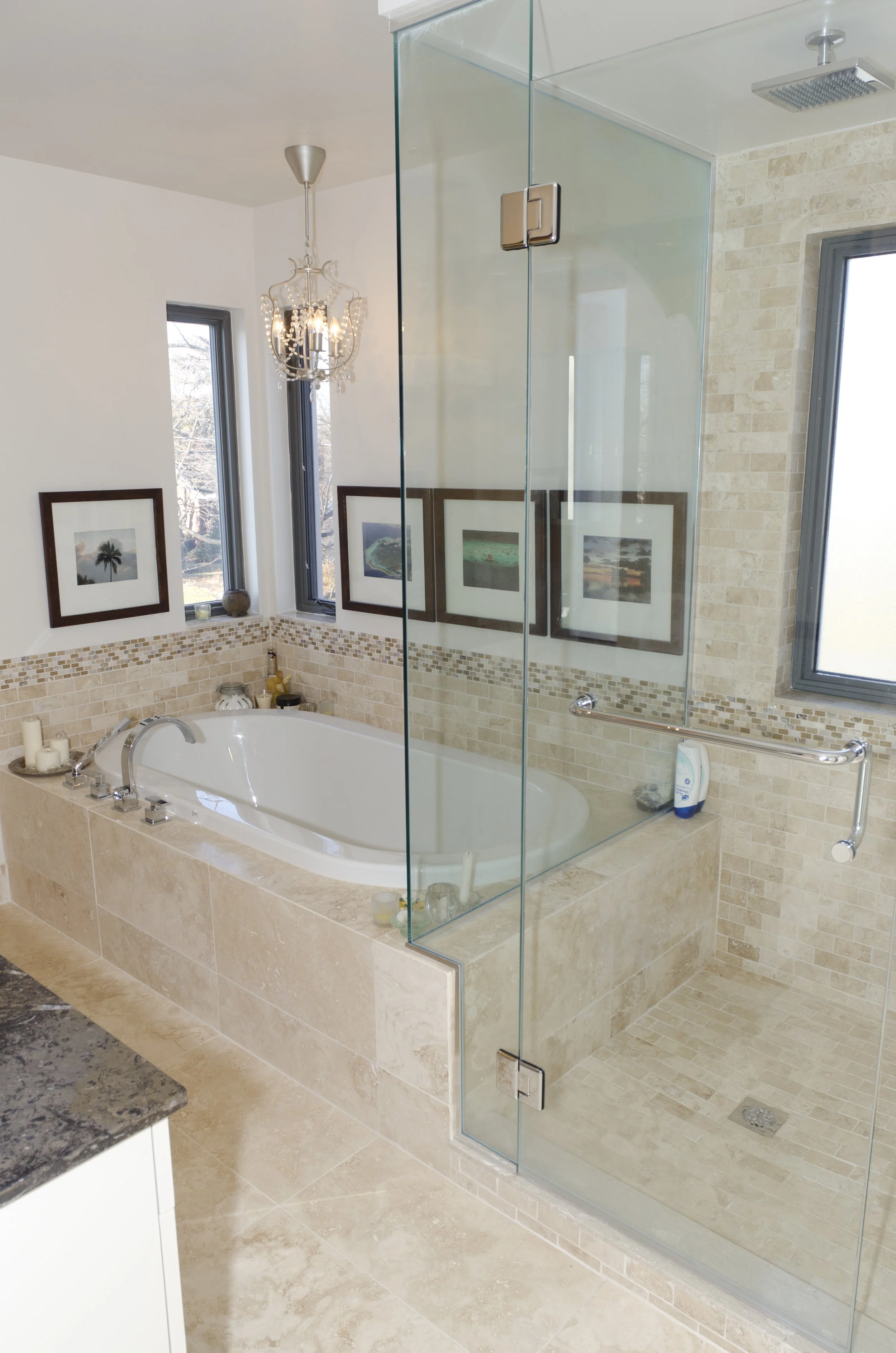 Bathroom with a bathtub and a separate glass-enclosed shower stall with beige tile and a window.