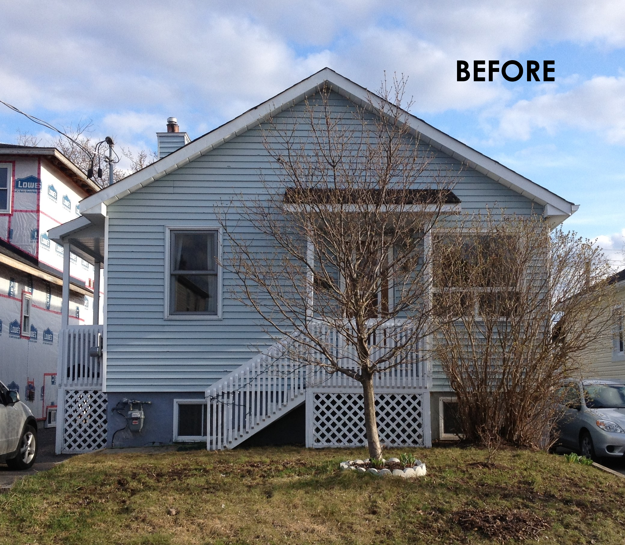 The back of a two-story house with light blue siding, a small staircase leading to a door, a leafless tree in front, and a grassy yard. The top right corner has the word 'BEFORE'.