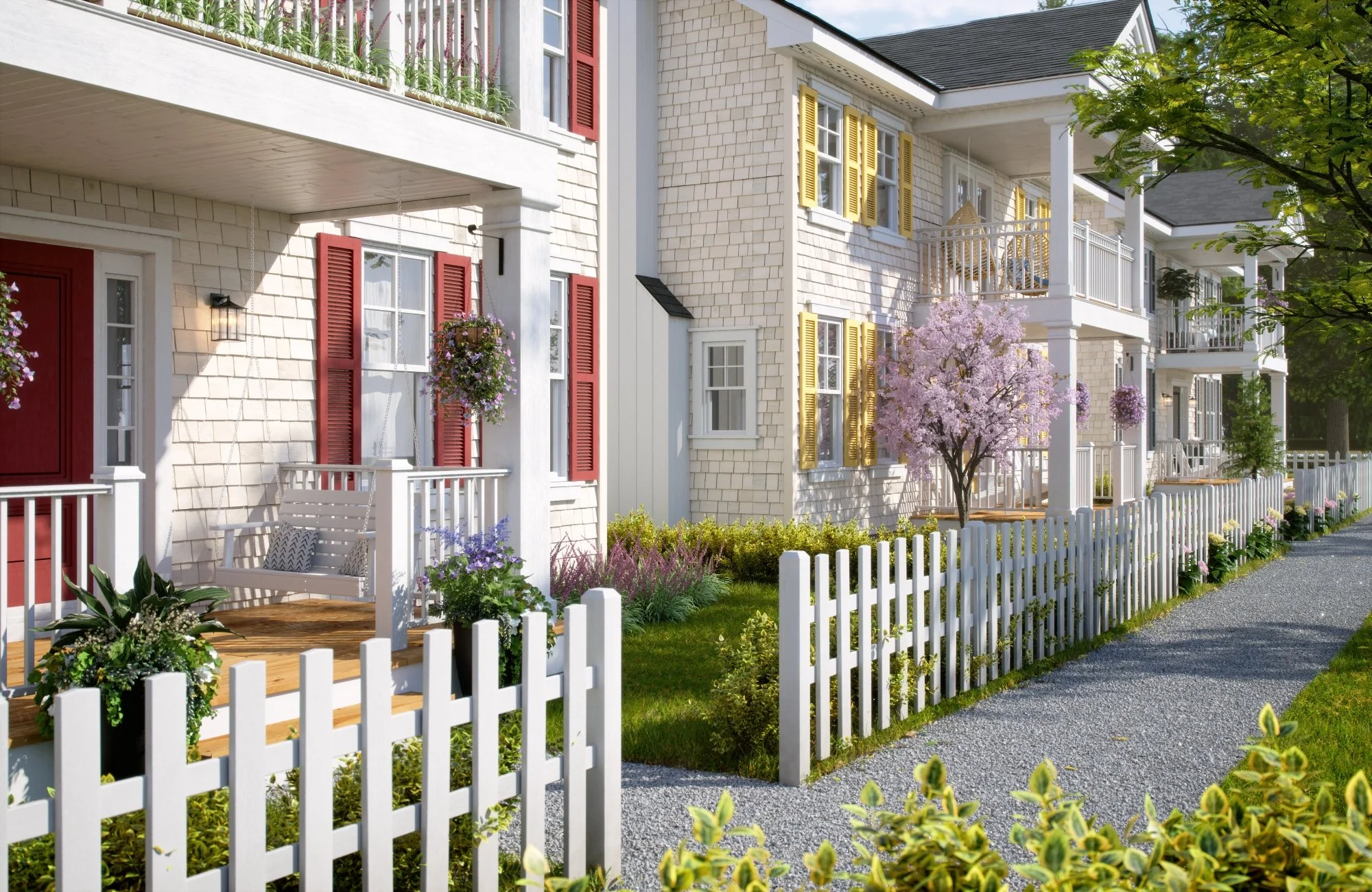 A row of white houses with 2 storey covered porches, red and yellow shutters, wood shake siding, surrounded by a white picket fence, green grass, blooming flowers, and trees, on a sunny day.