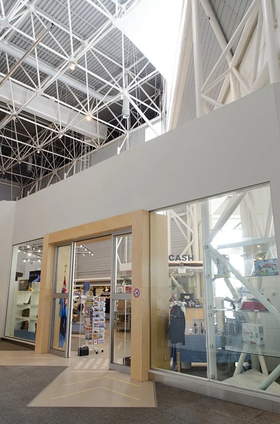 Entrance to a retail store with glass doors and a sign that says 'CASH', inside shelves with various products and accessories visible.