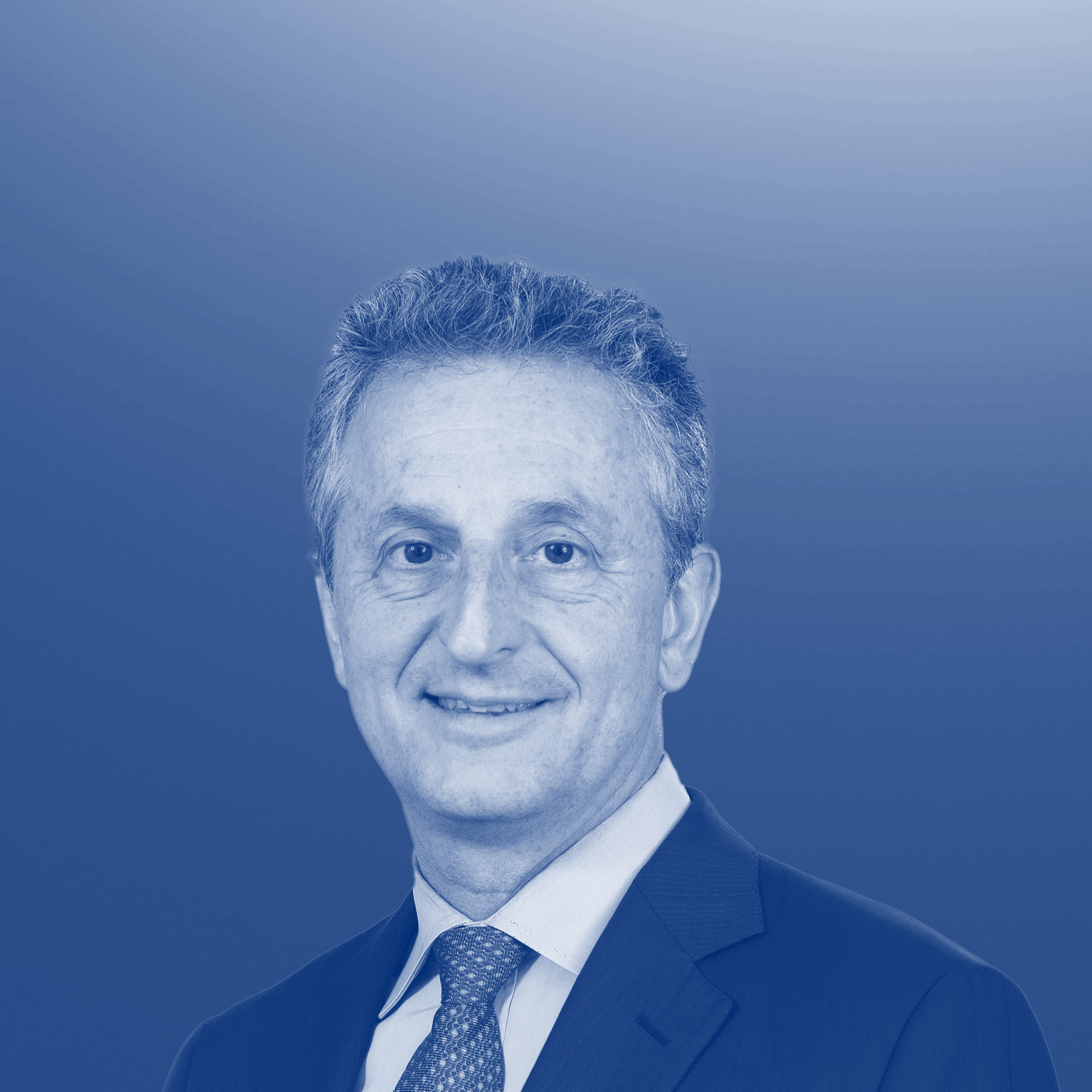 Portrait of a man in a suit with a blue gradient background.