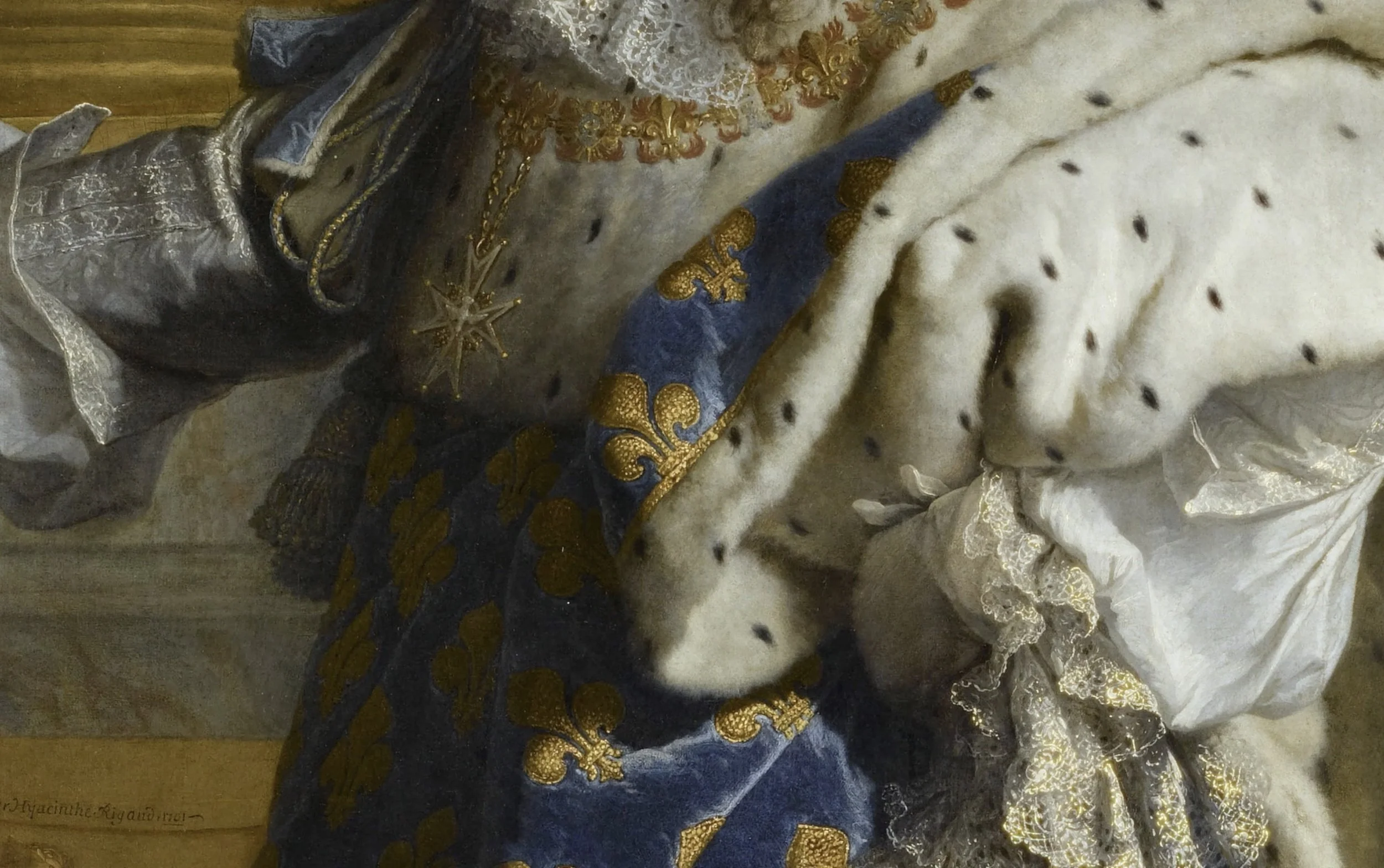 Détail d'une robe royale ornée de velours bleu et broderies dorées, avec un manteau en fourrure blanche avec taches noires, et des bijoux en or dont un collier et une étoile suspendue.