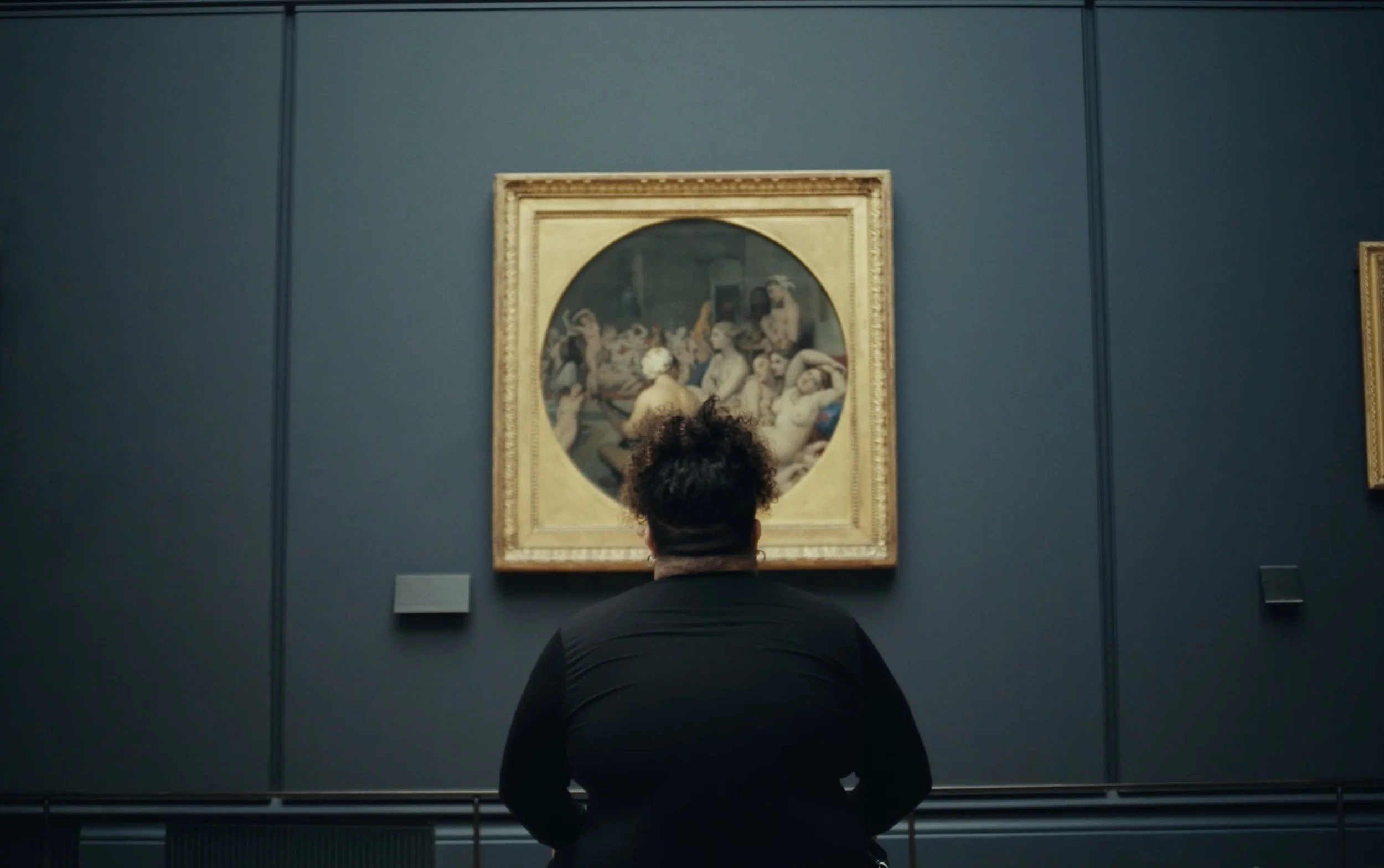 Personne regardant une peinture dans un musée.