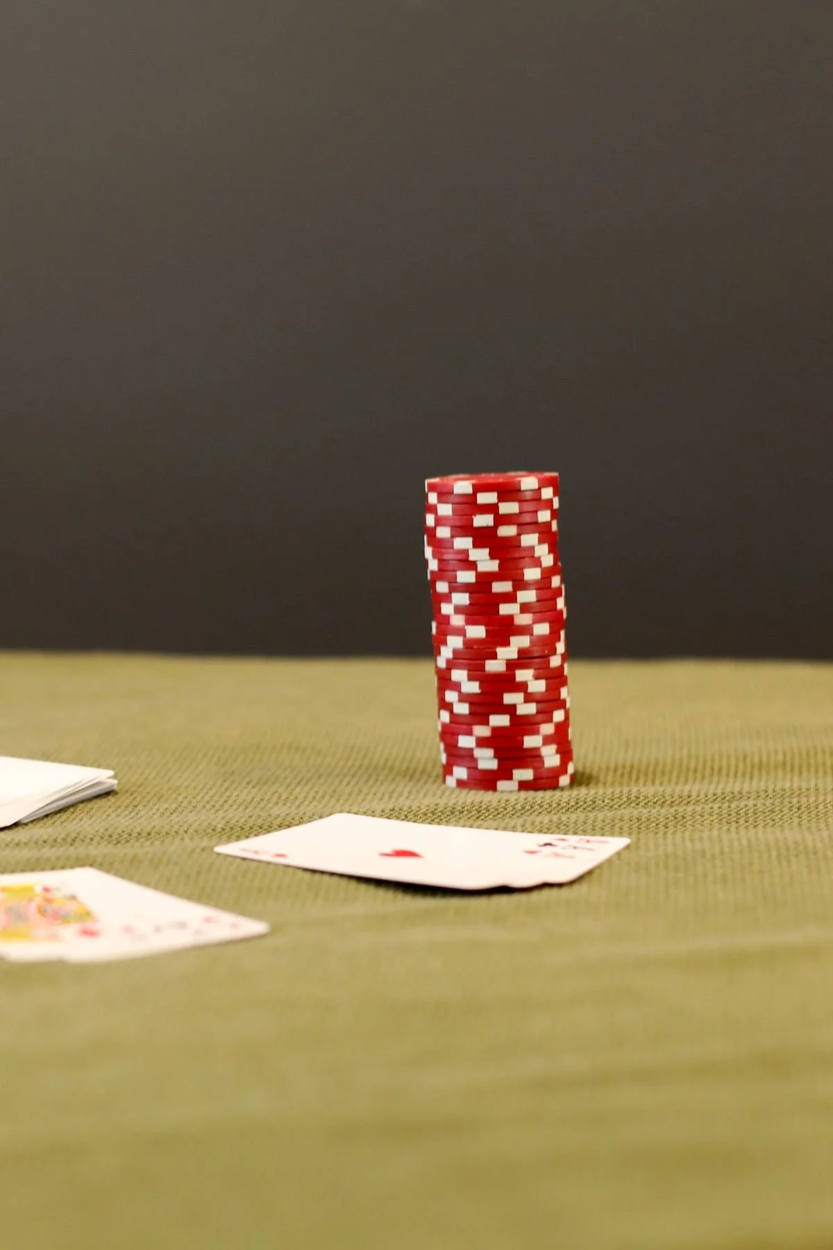 Poker chips and playing cards on a green felt table