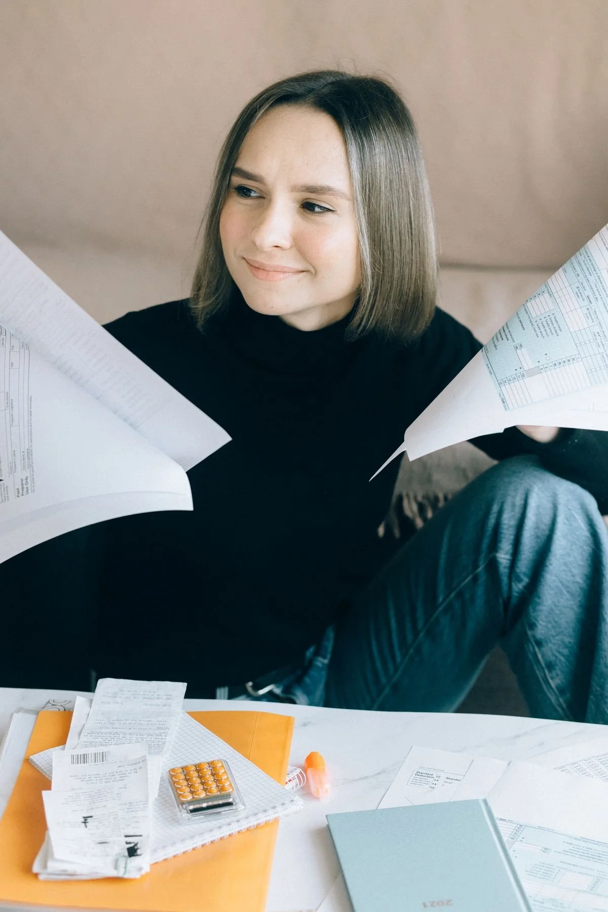 Sorting tax documents at a home office desk
